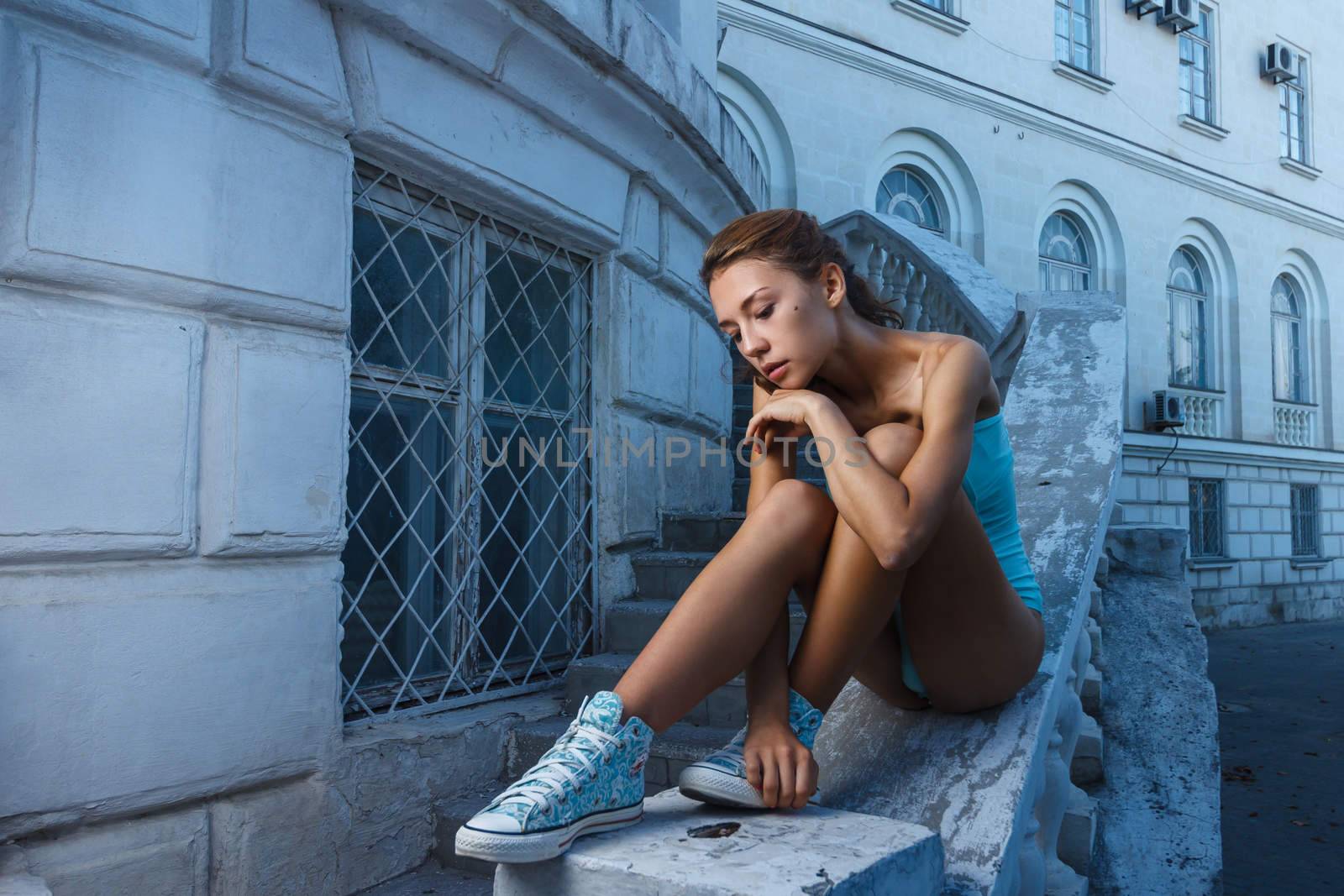 Beautiful girl in bodysuit posing with classical building at background by mrakor