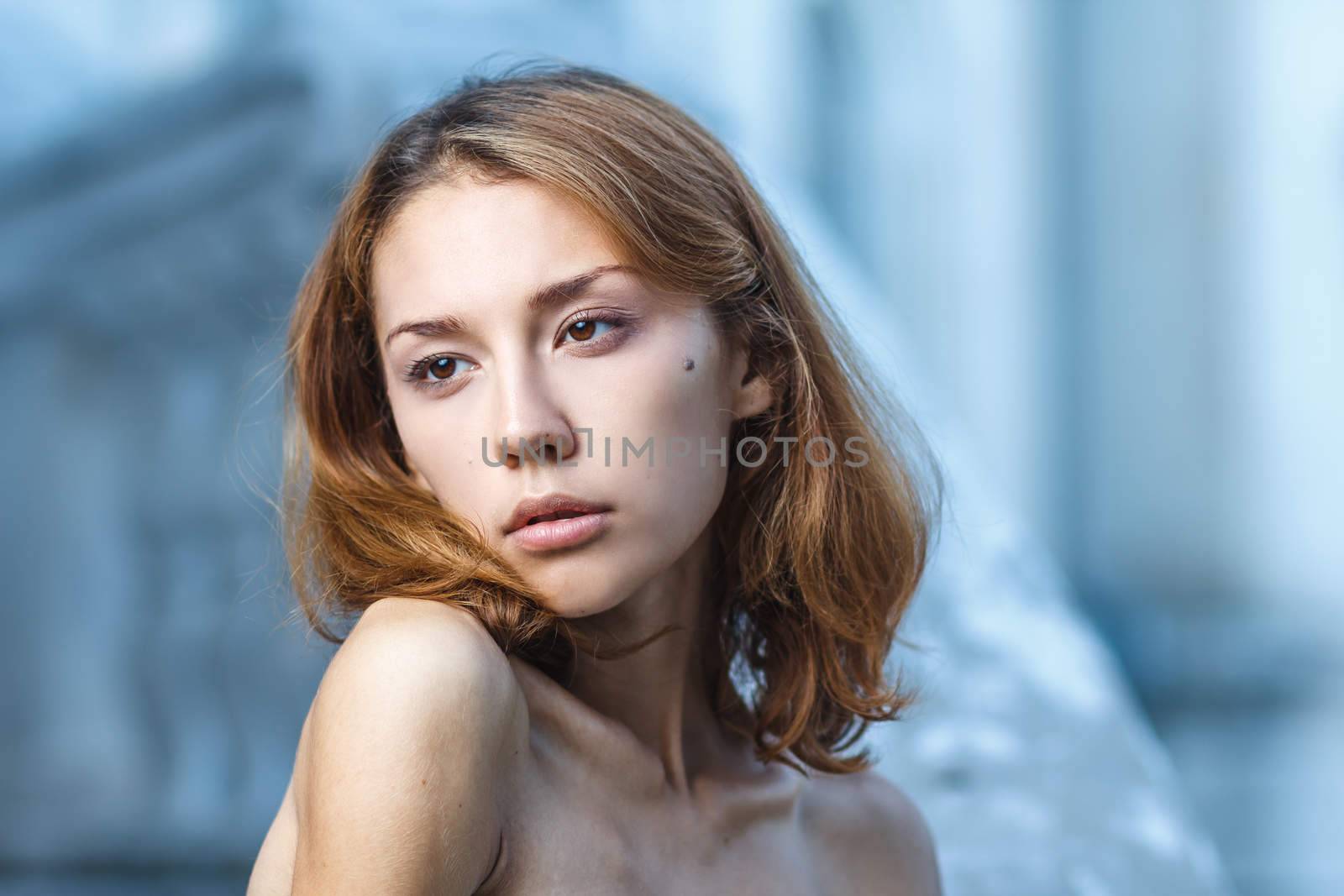 Fashion portrait shoot of a beautiful teen girl during city fashion shoot with classical building at background