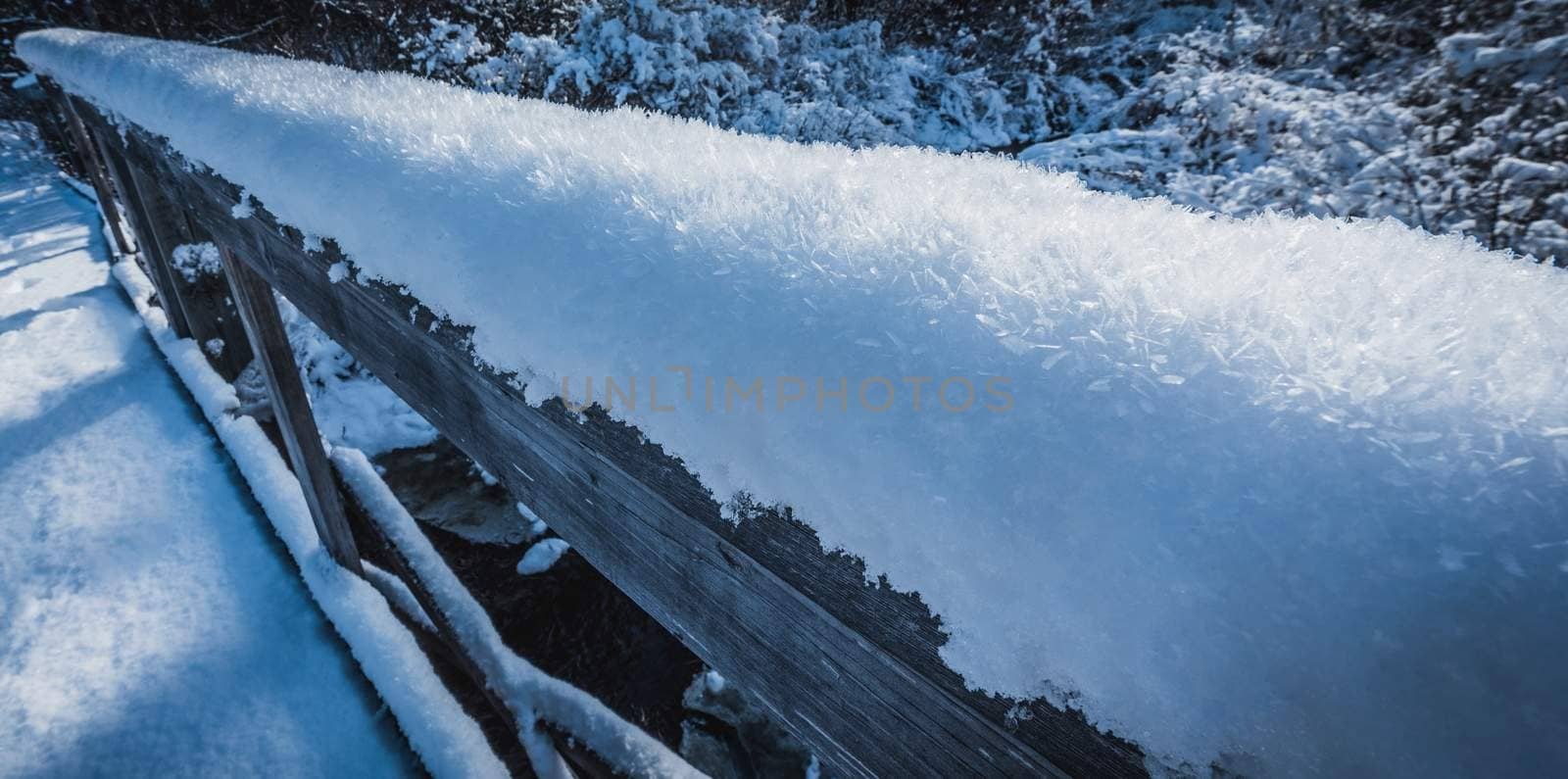 Snow flakes covered in large frost crystals. Fresh fallen snow, further covered by layers of frost, manifesting from the warmer water's rising mist nearby.