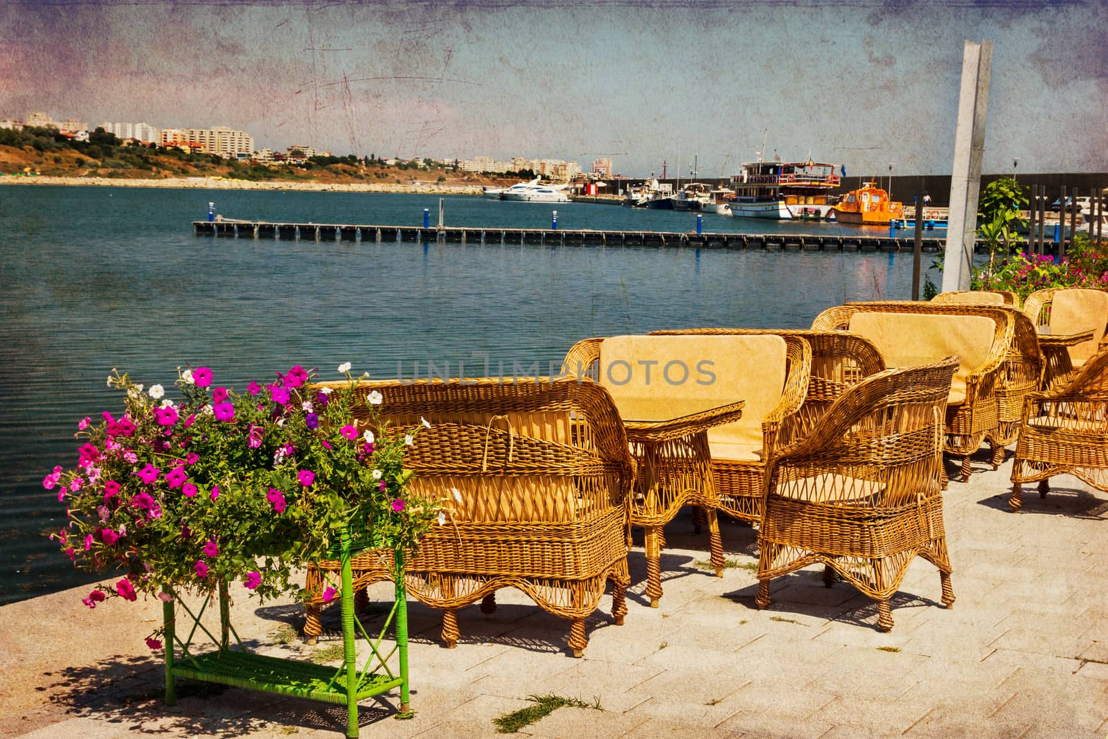 Rattan tables, chairs and benches at a terrace in Tomis harbor in Constanta Romania at the Black Sea