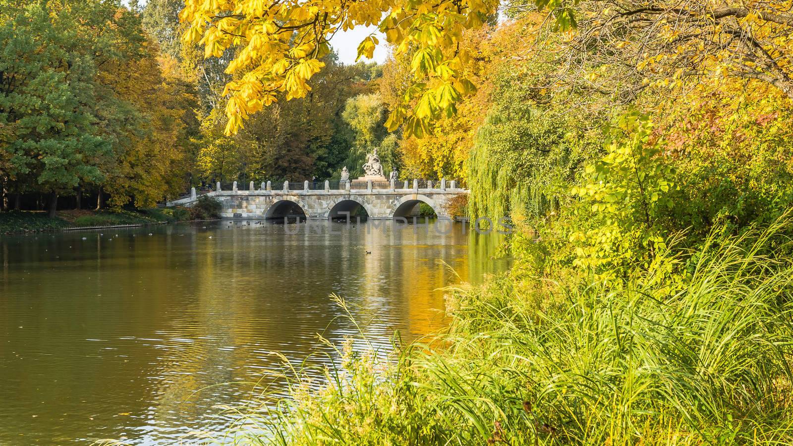 The Lazienki Park (Royal Baths) Park in Warsaw, Poland in  the autumn day. In the background monument to Polish king Jan III Sobieski.