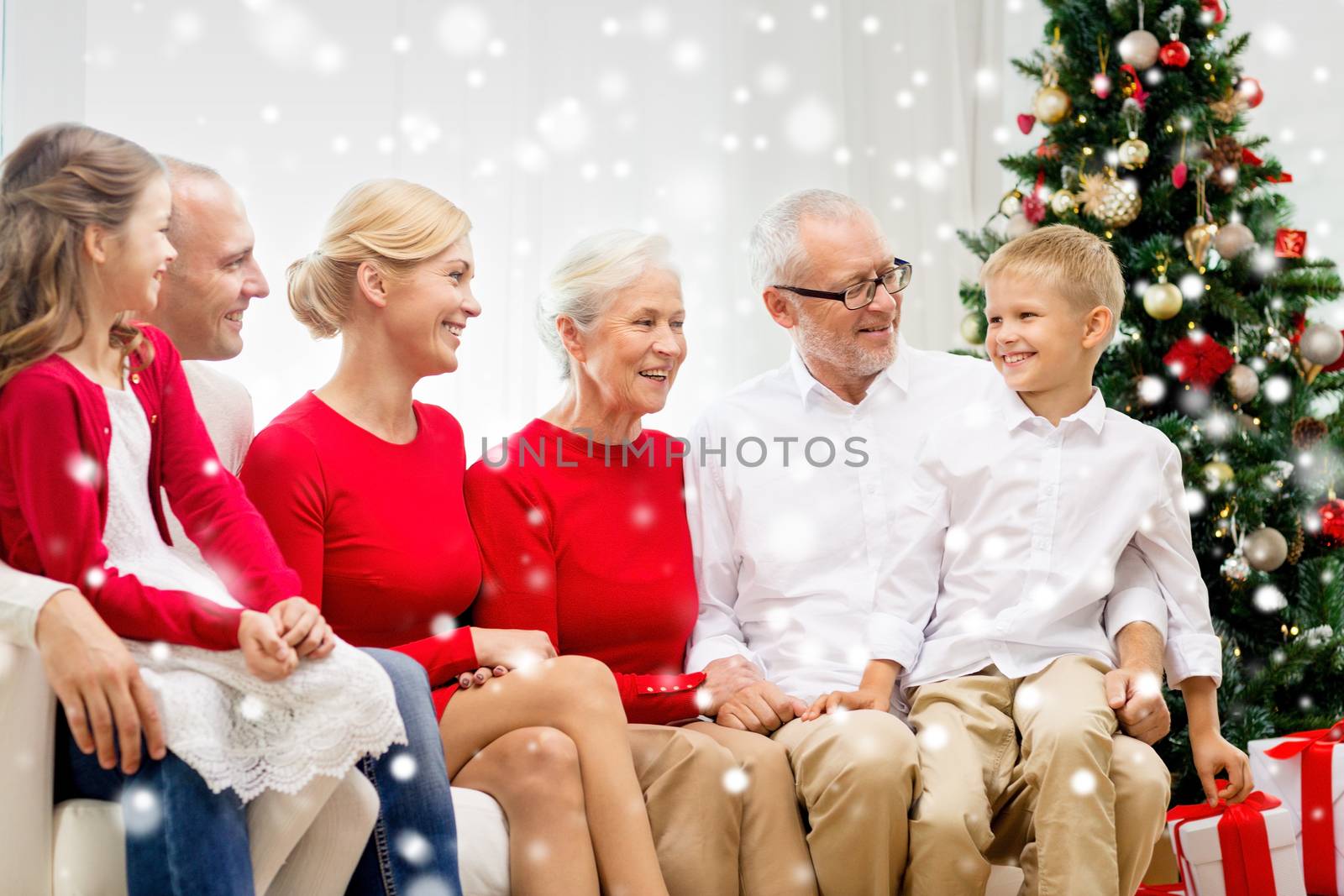 family, holidays, generation, christmas and people concept - smiling family sitting on couch at home