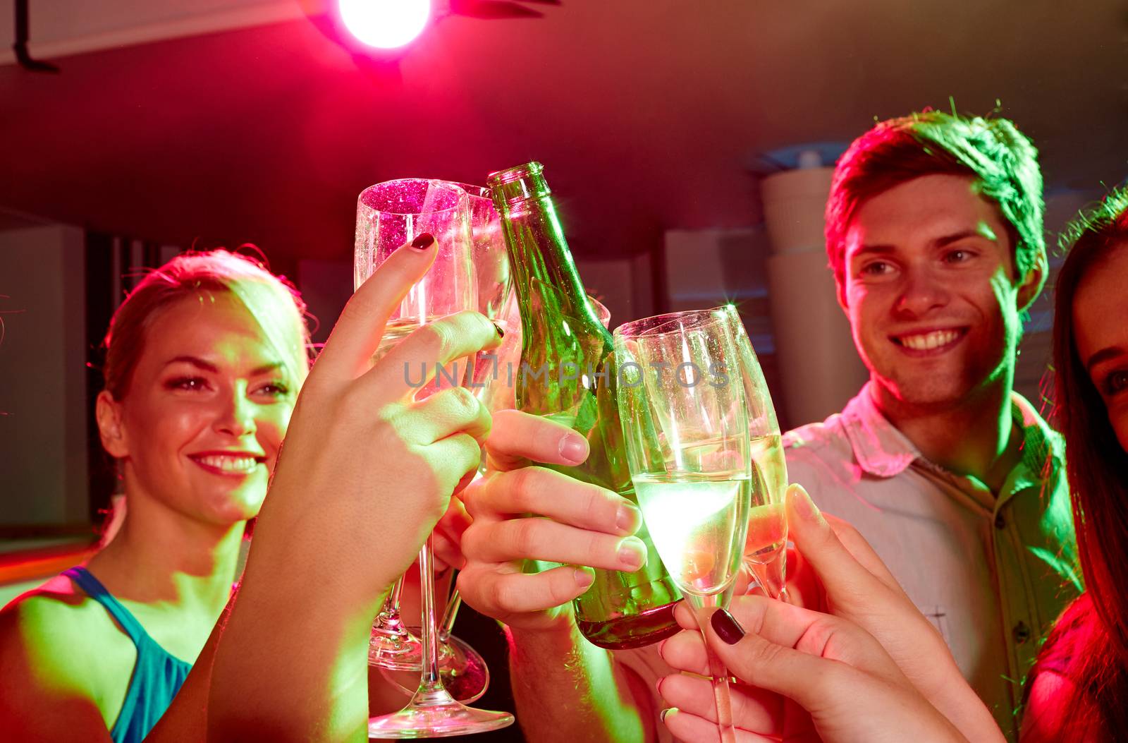 party, holidays, celebration, nightlife and people concept - smiling friends clinking glasses of champagne and beer in club