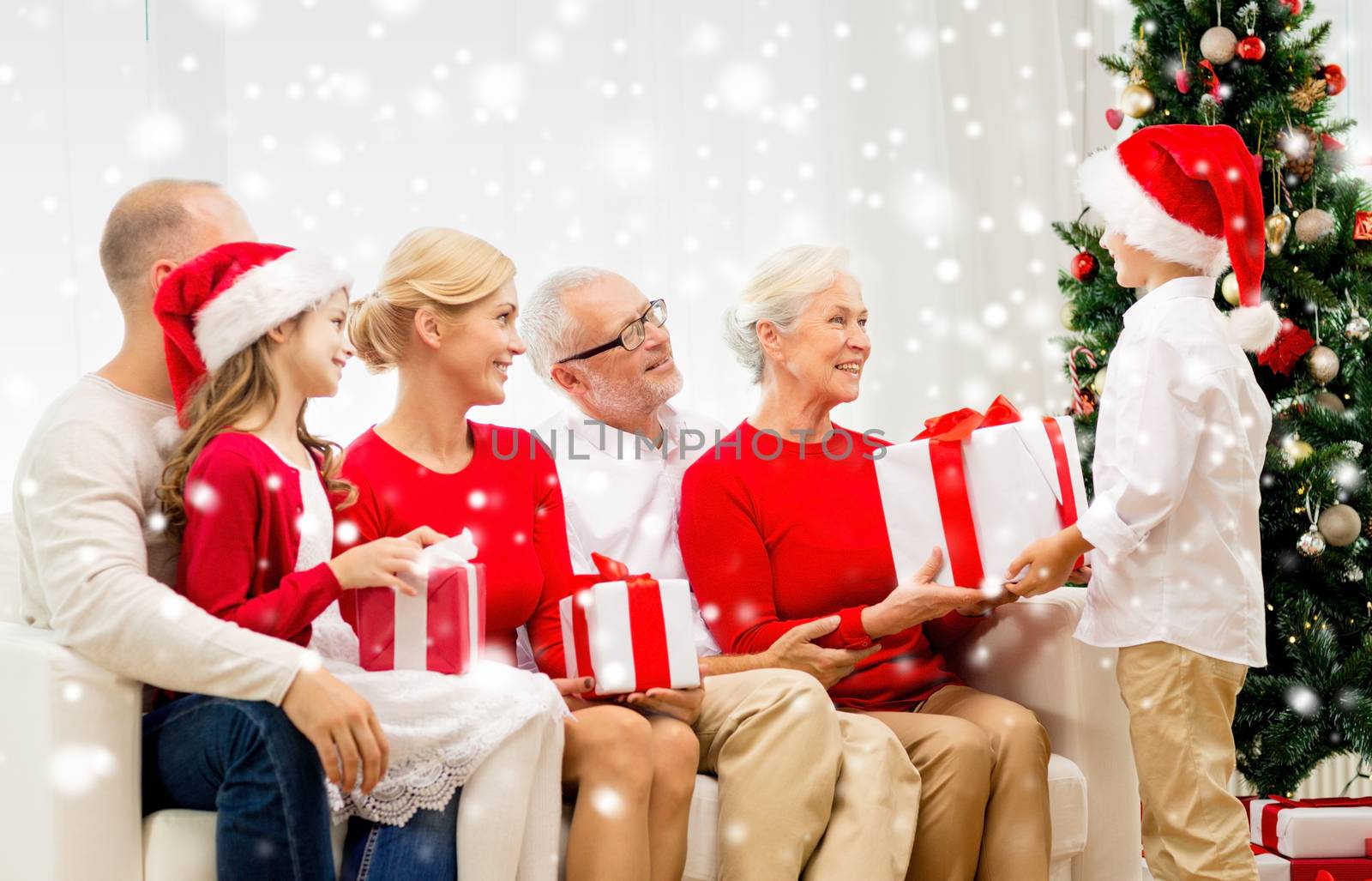 family, holidays, generation, christmas and people concept - smiling family with gift boxes sitting on couch at home