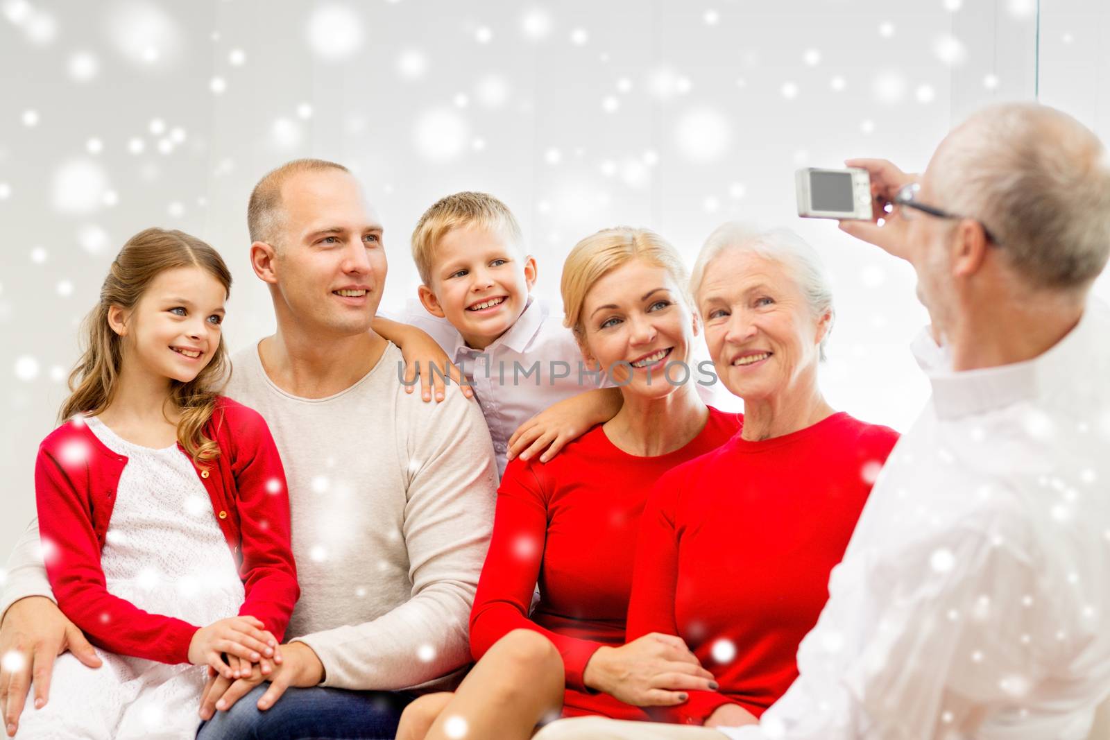 smiling family with camera at home by dolgachov