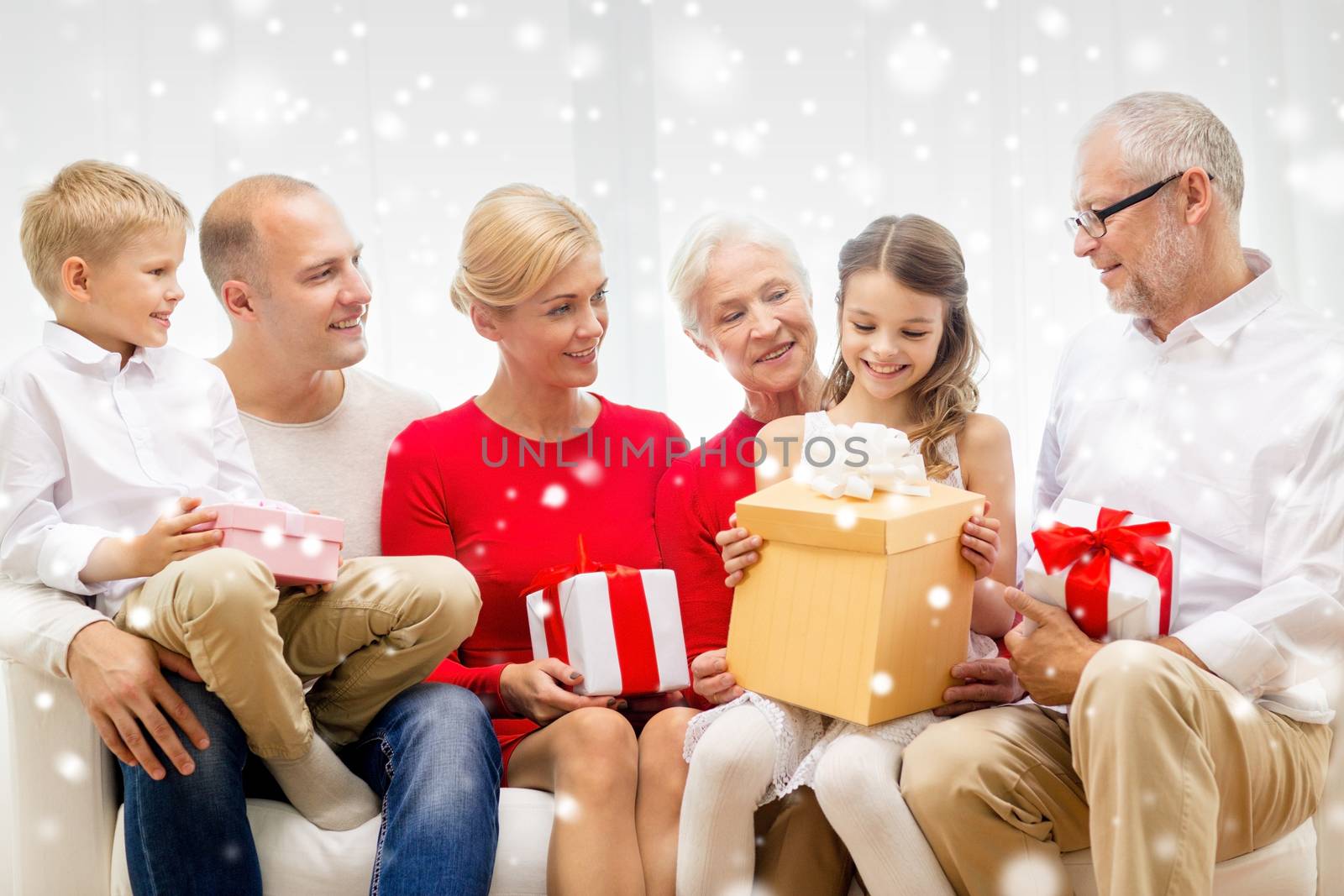 family, holidays, generation, christmas and people concept - smiling family with gift boxes sitting on couch at home