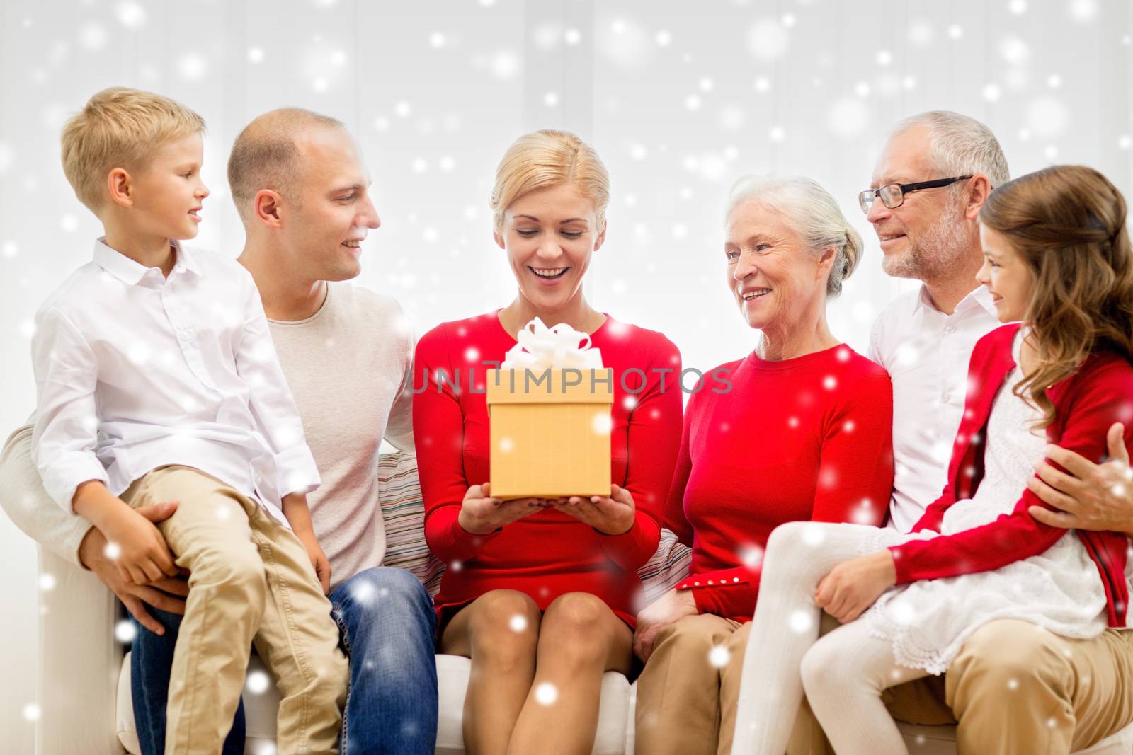 family, holidays, generation, christmas and people concept - smiling family with gift boxes sitting on couch at home