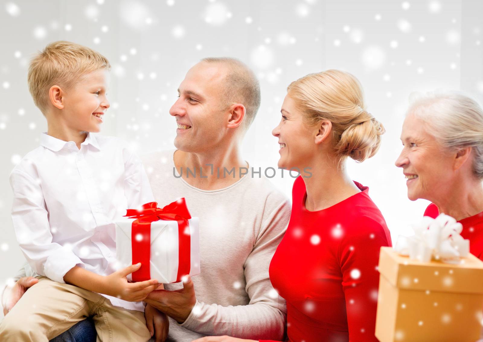 family, holidays, generation, christmas and people concept - smiling family with gift boxes sitting on couch at home