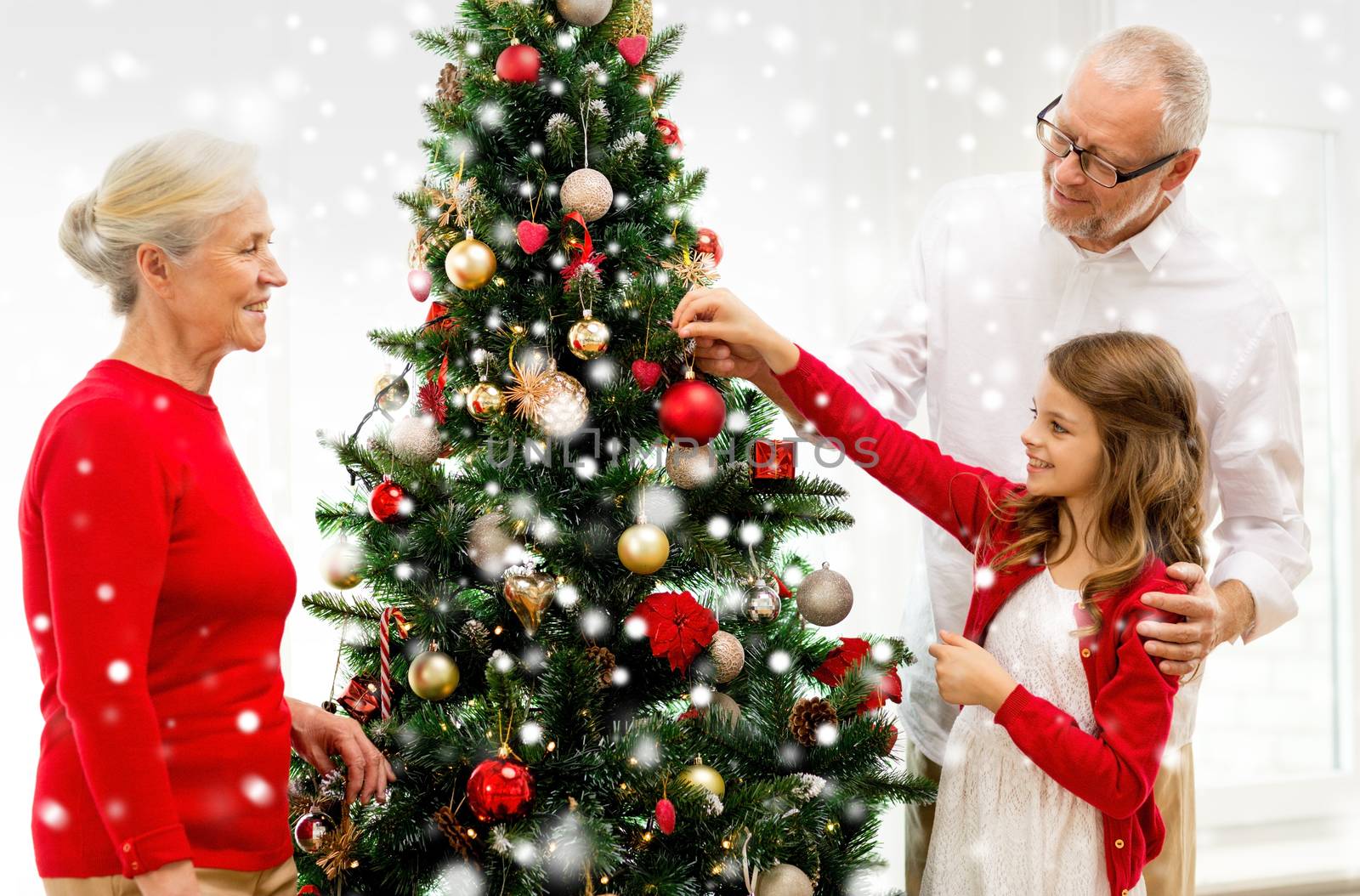 smiling family decorating christmas tree at home by dolgachov