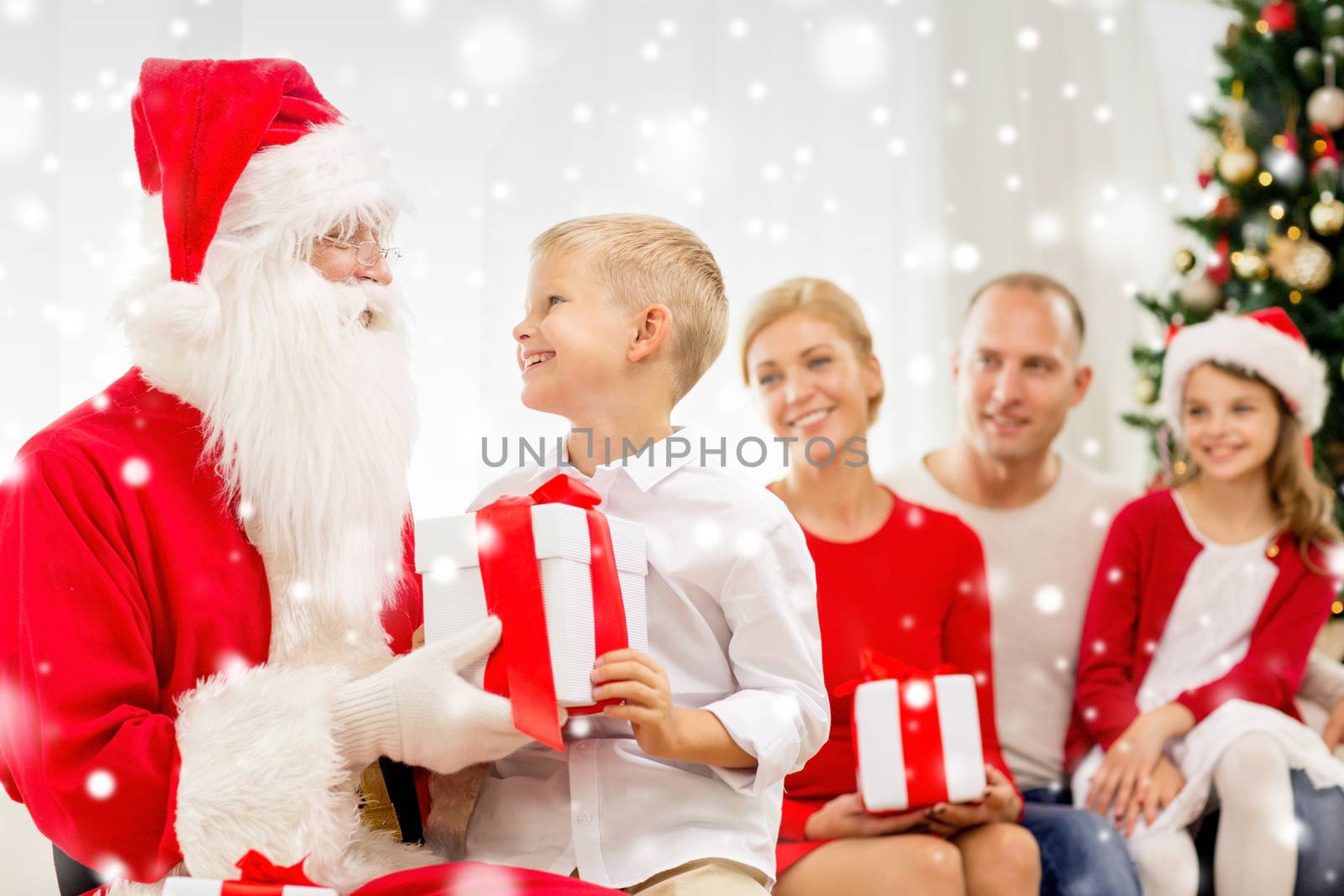 family, holidays, generation, christmas and people concept - smiling family with santa claus and gift boxes at home