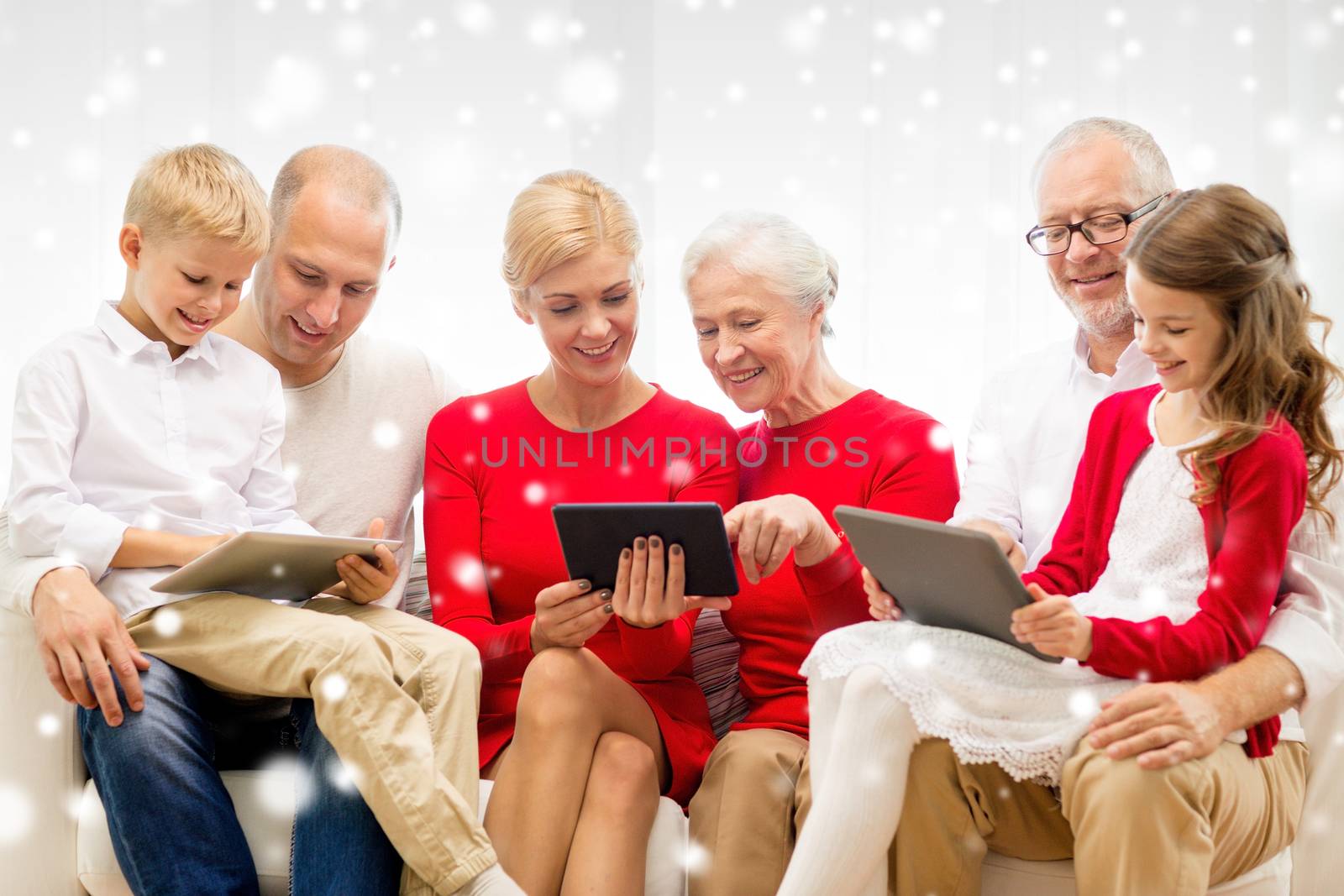 family, holidays, christmas, technology and people concept - smiling family with tablet pc computers sitting on couch at home