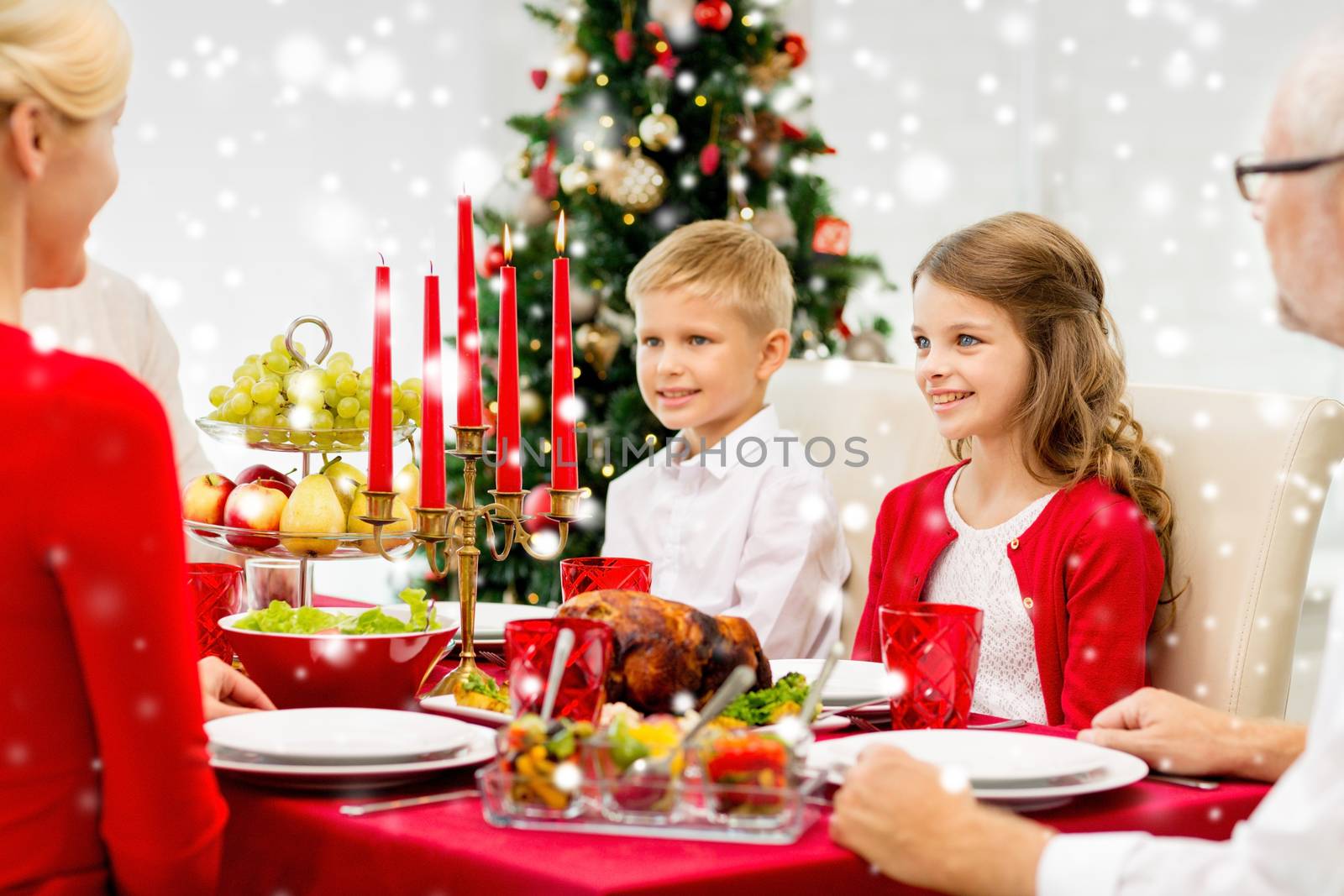 smiling family having holiday dinner at home by dolgachov