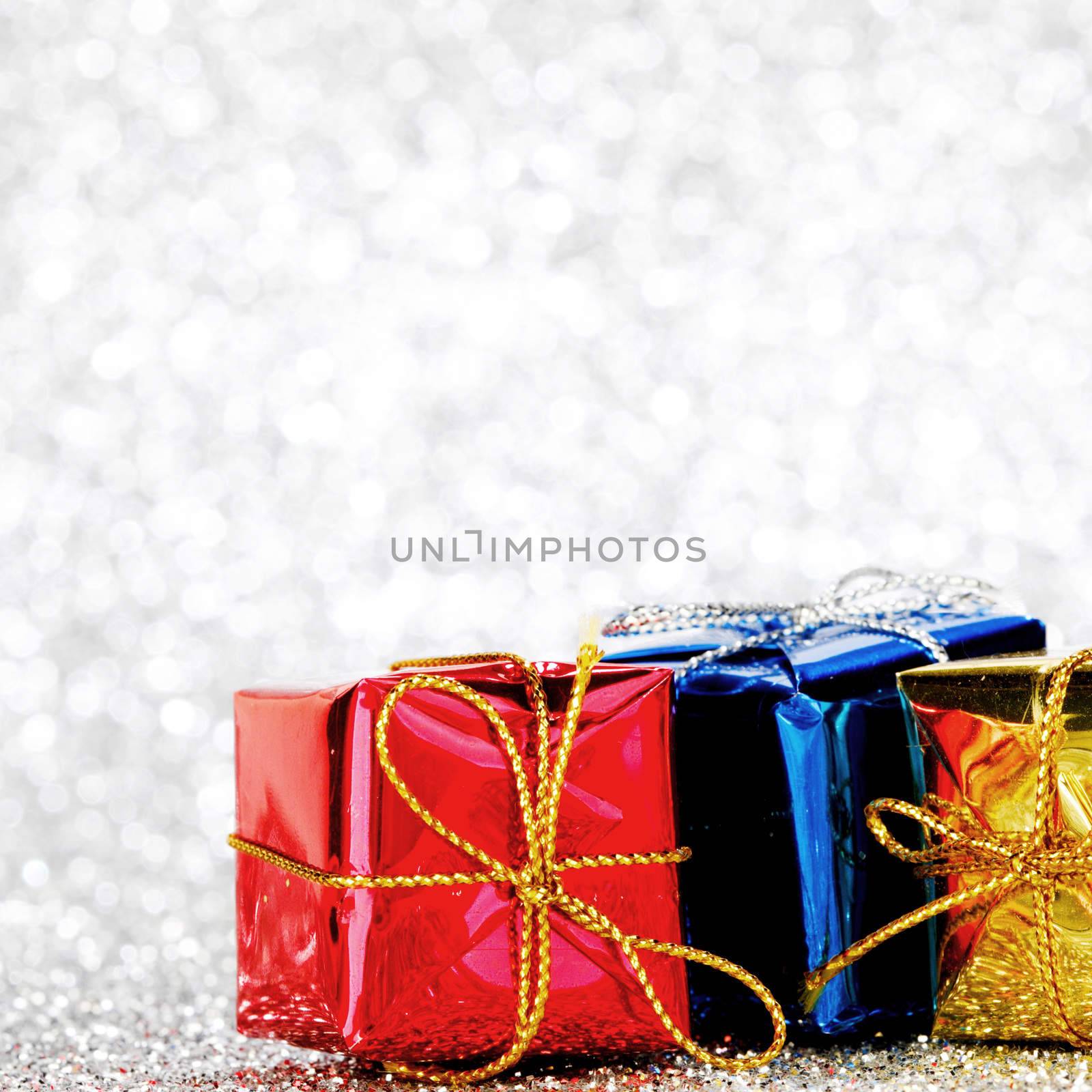 Decorated holiday gifts on silver background