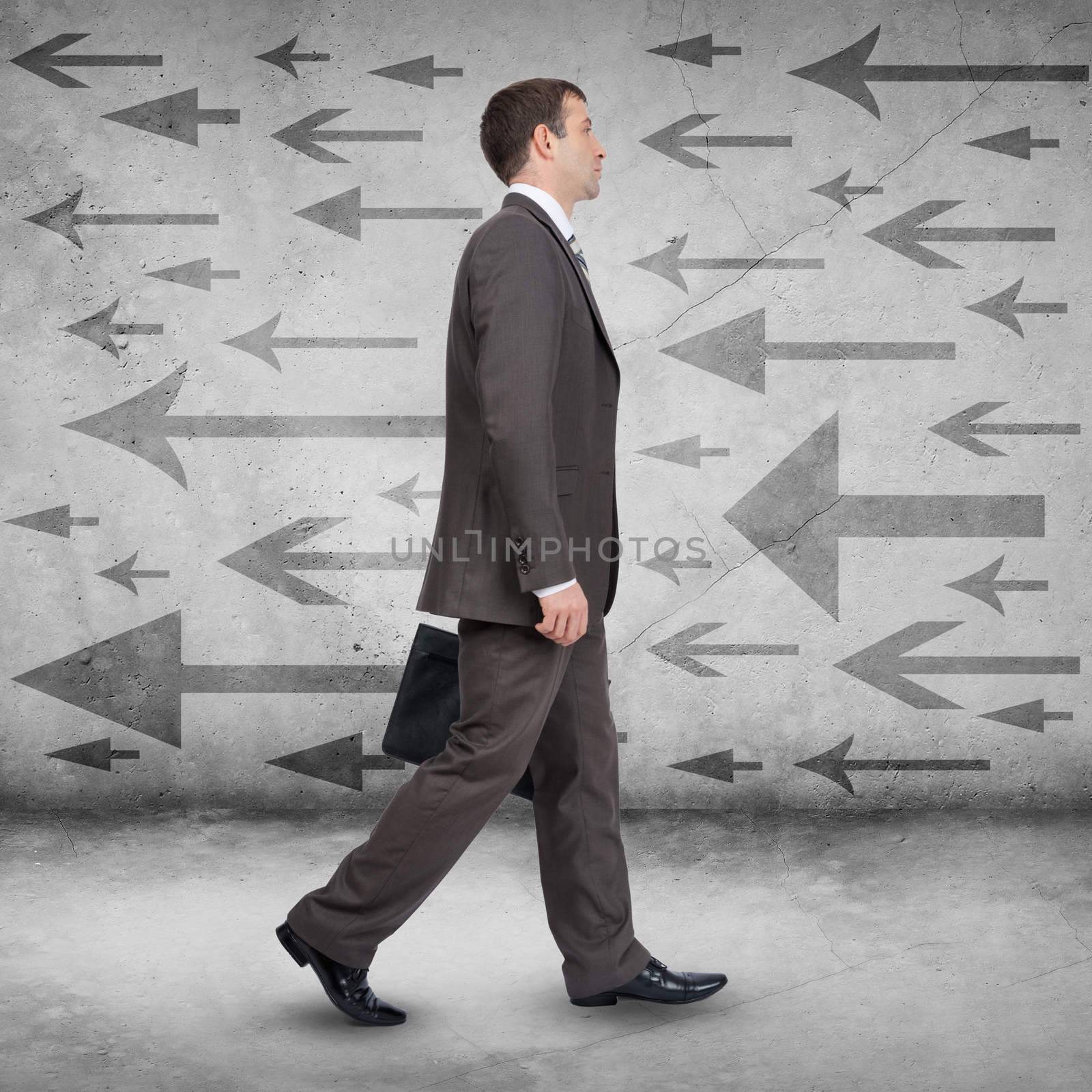 Businessman walking on abstract background with arrows