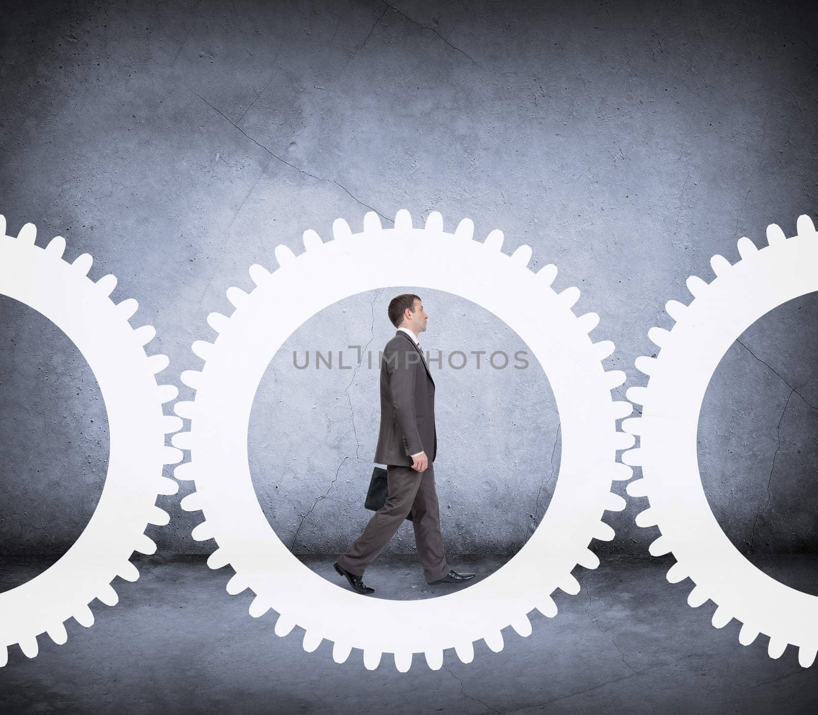 Businessman walking in cog wheel on abstract background