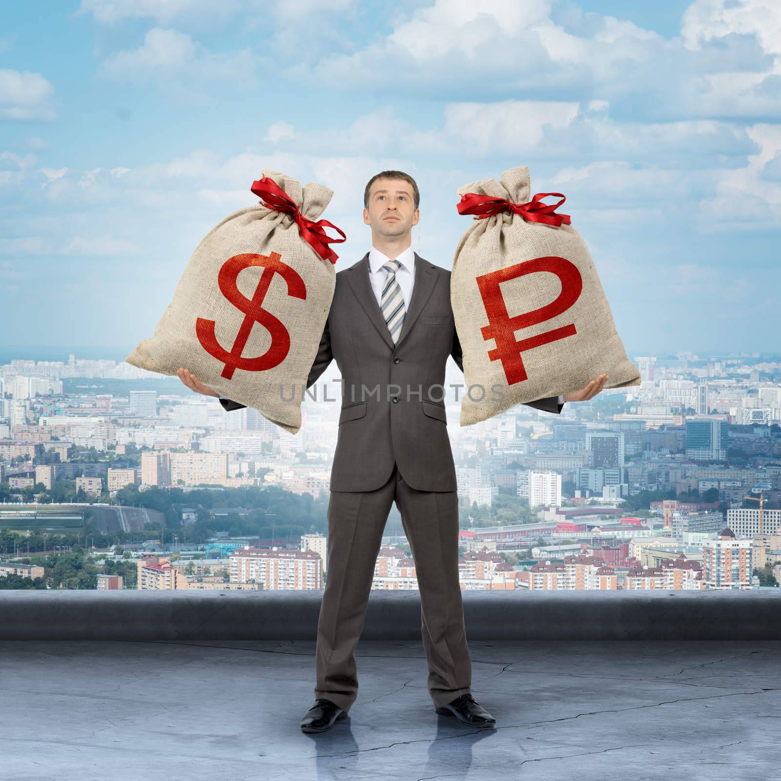 Businessman holding big moneybag with dollar and ruble signs