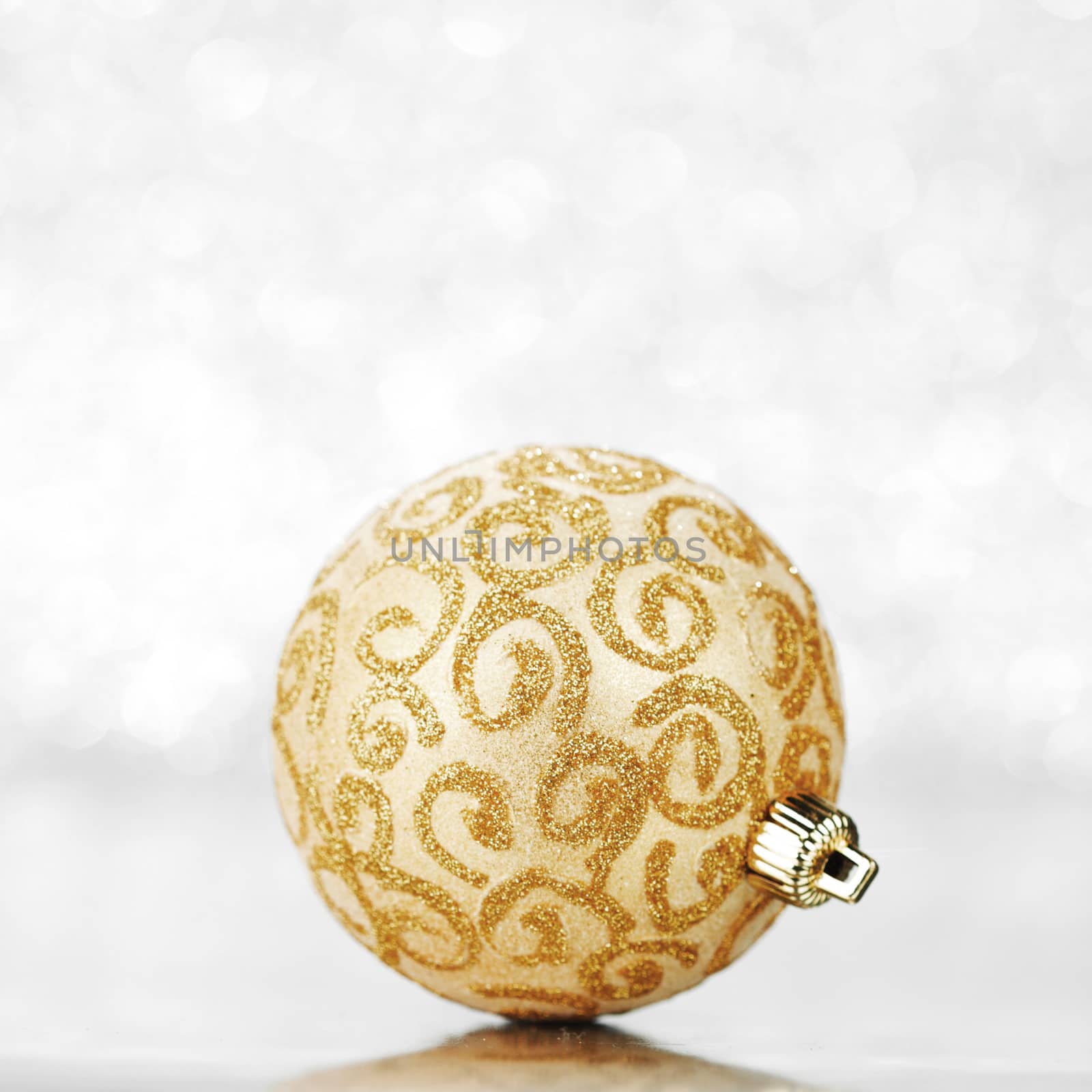 Beautiful golden christmas ball on abstract glitter background close-up