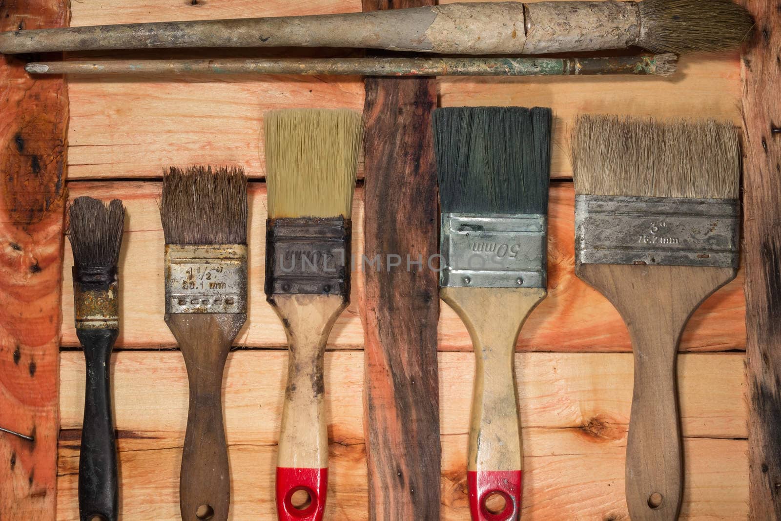 Used paintbrushes on a old wooden table.