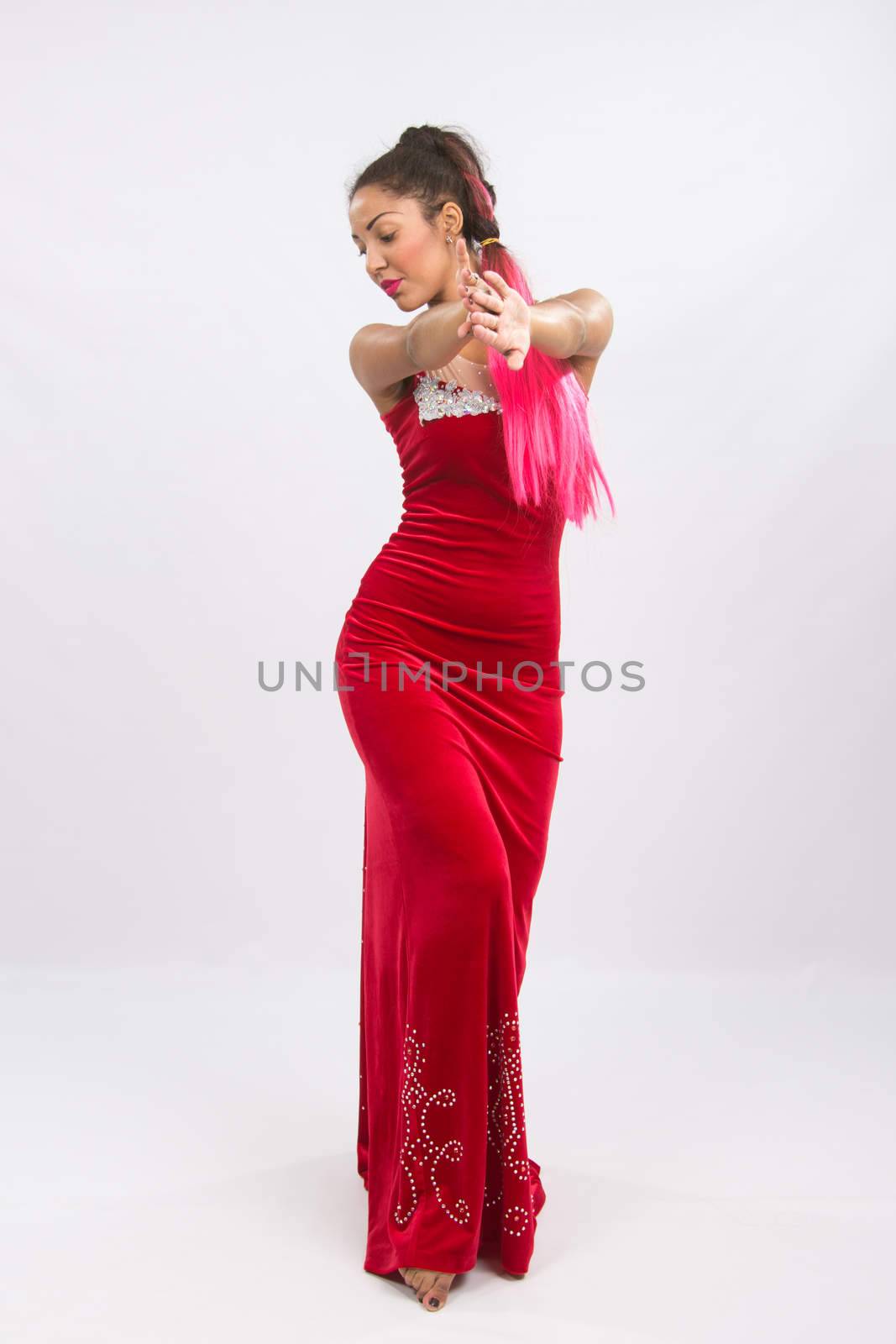 Mulatto girl dancer performs a dance elements, isolated on a light background