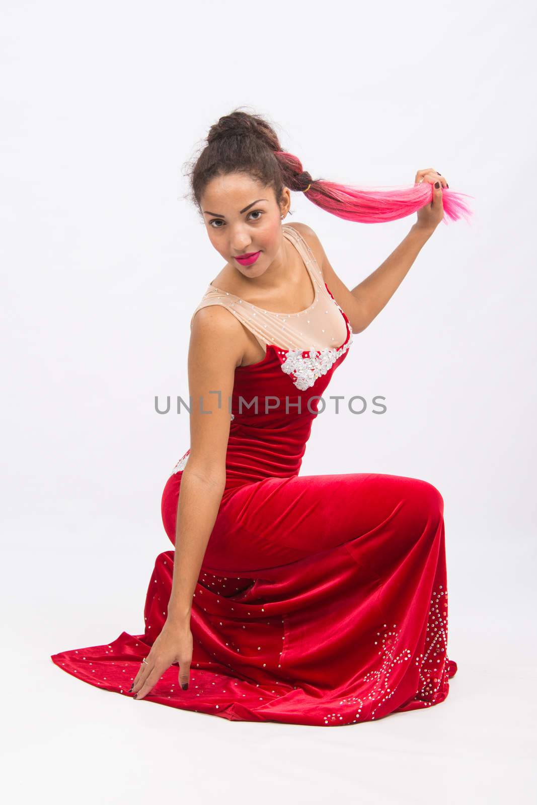 Mulatto girl dancer performs a dance elements, isolated on a light background