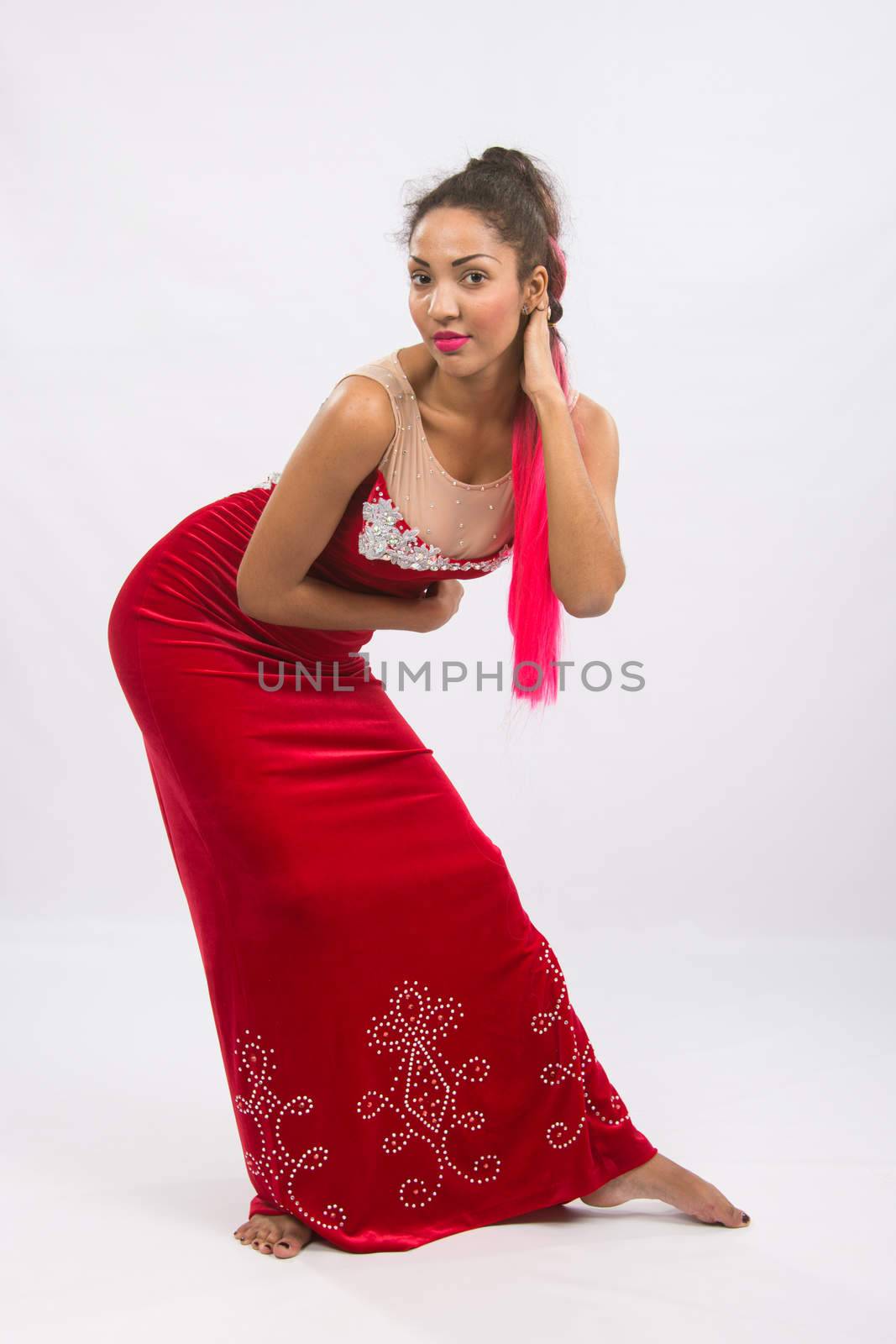 Mulatto girl dancer performs a dance elements, isolated on a light background