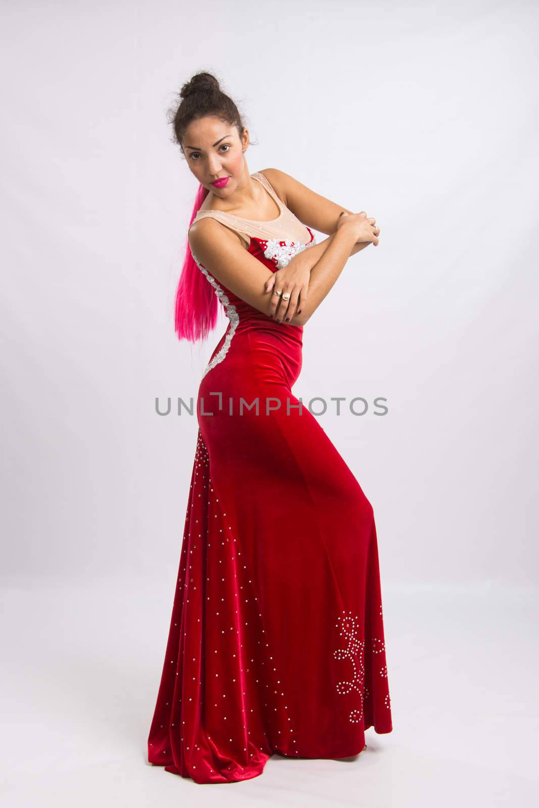 Mulatto girl dancer performs a dance elements, isolated on a light background