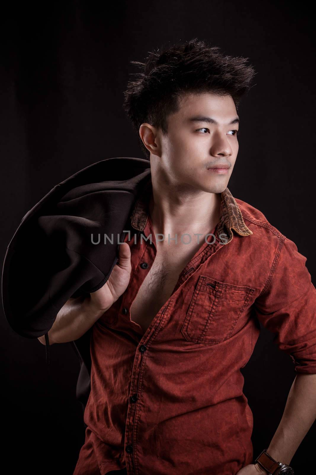 Portrait of Asian young man on black background - casual red shirt