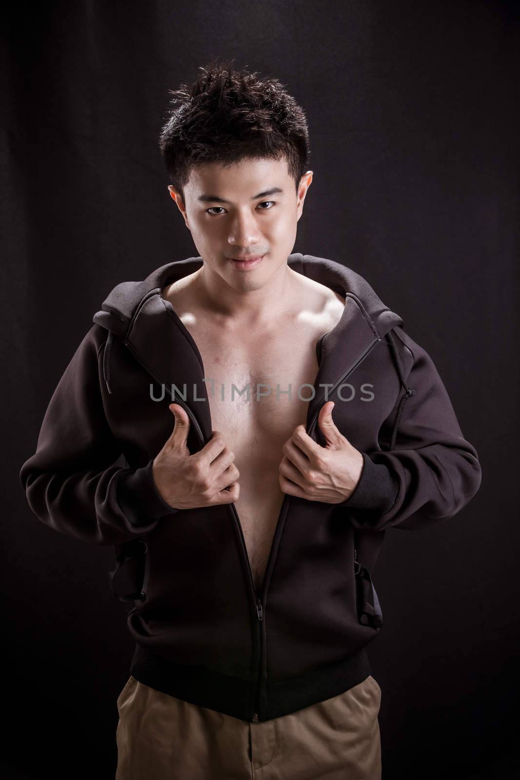 Portrait of Asian young man on black background - Fitness healthy guy thumb up