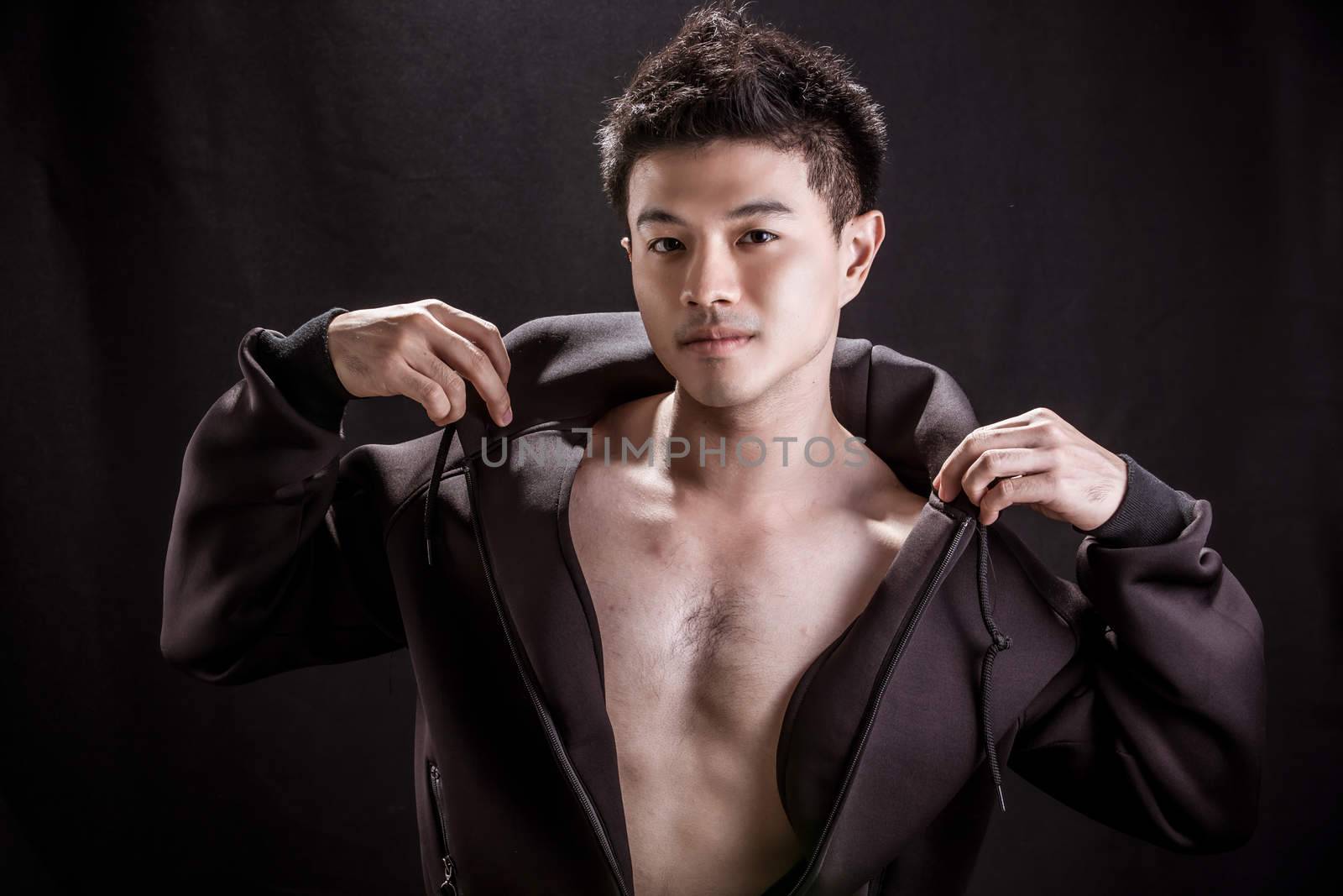 Portrait of Asian young man on black background - Fitness healthy guy