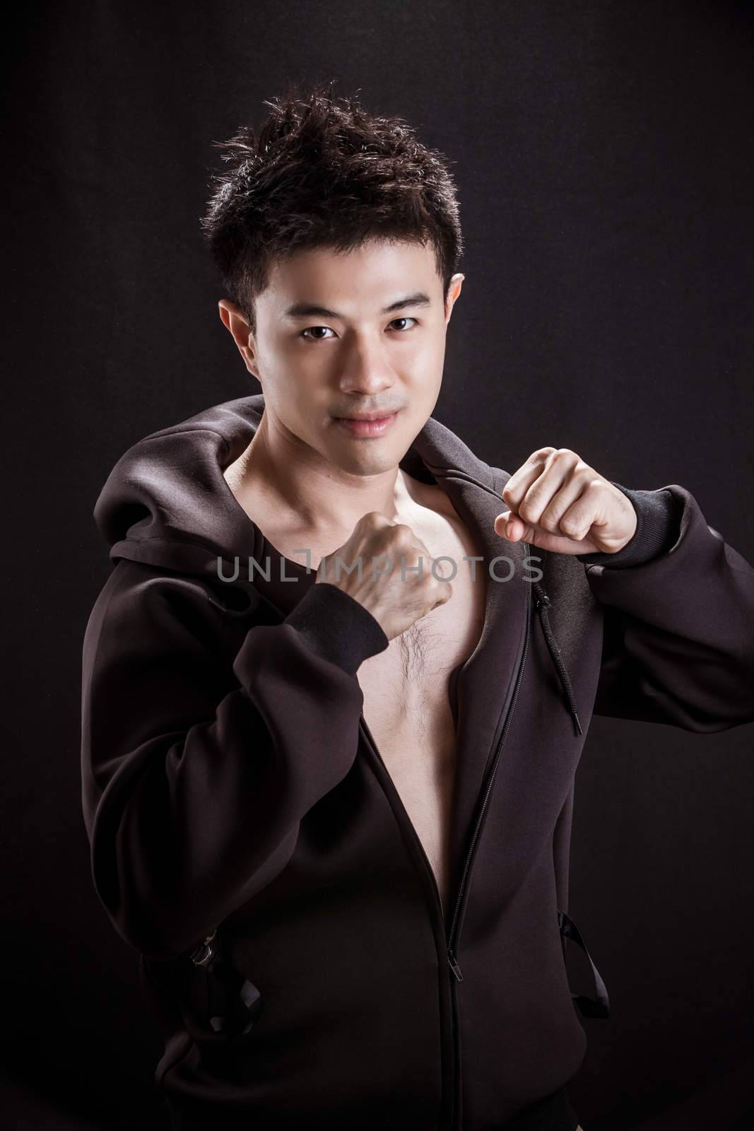 Portrait of Asian young man on black background - Fitness healthy guy and fighter concpet