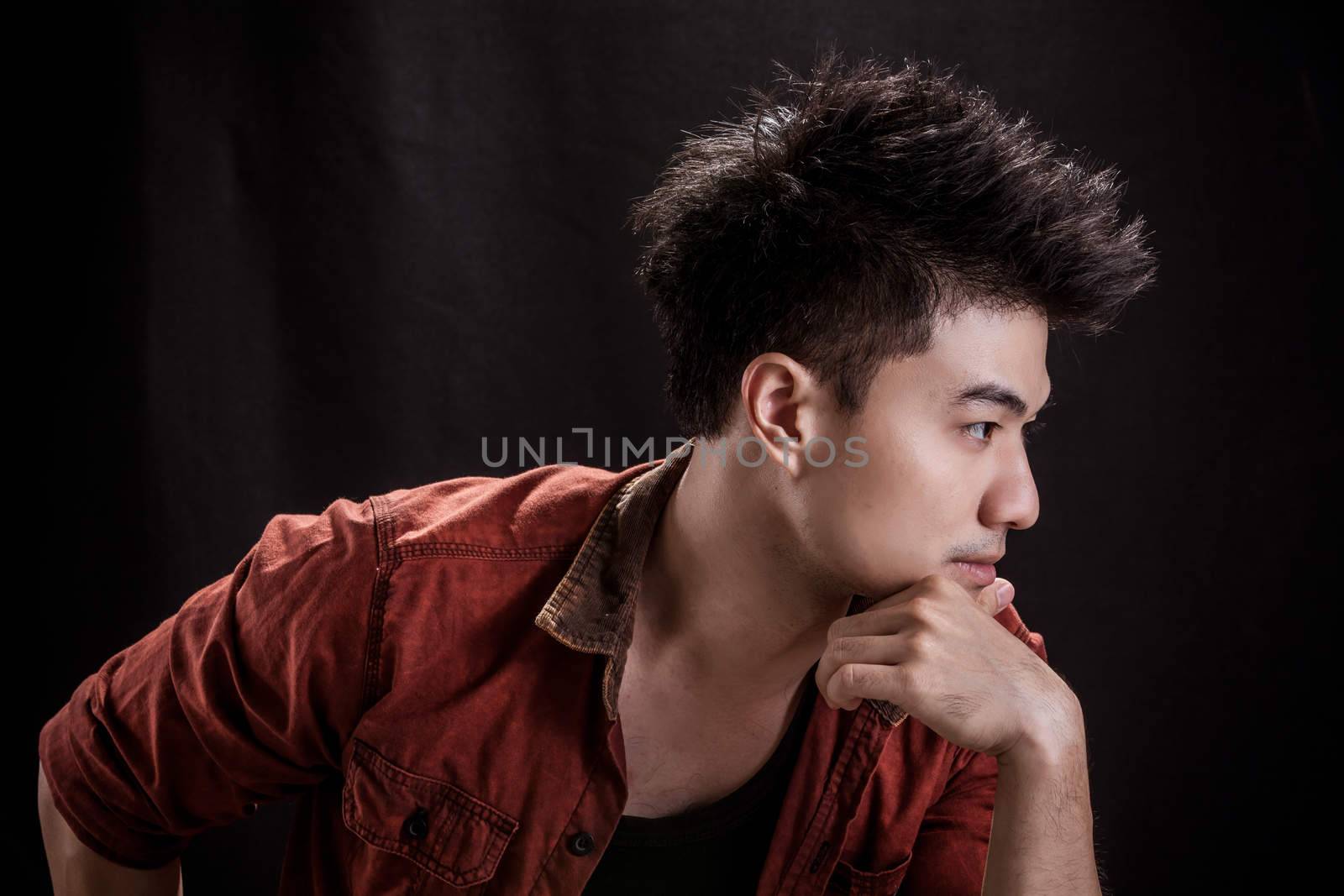 Portrait of Asian young man on black background - Casual red shirt and posing