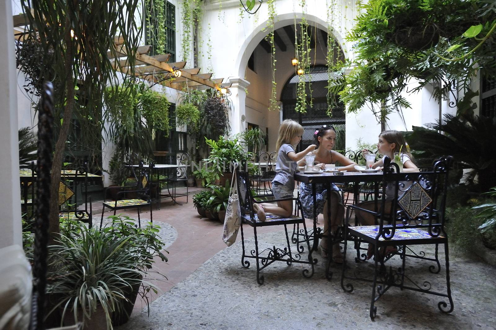 Family is having dinner in the old colonial  patio.