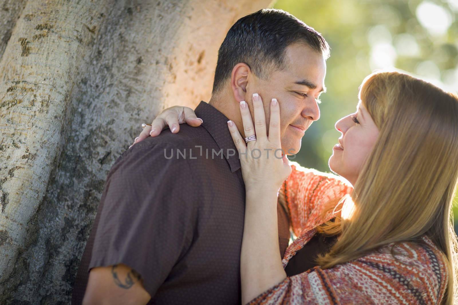 Mixed Race Couple Leaning Against Tree In a Romantic Moment by Feverpitched