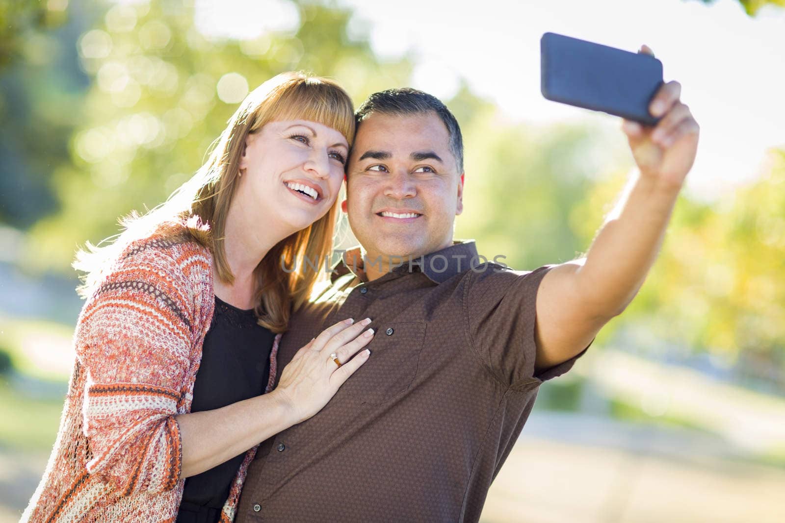 Attractive Mixed Race Couple Taking Self Portraits in the Park.