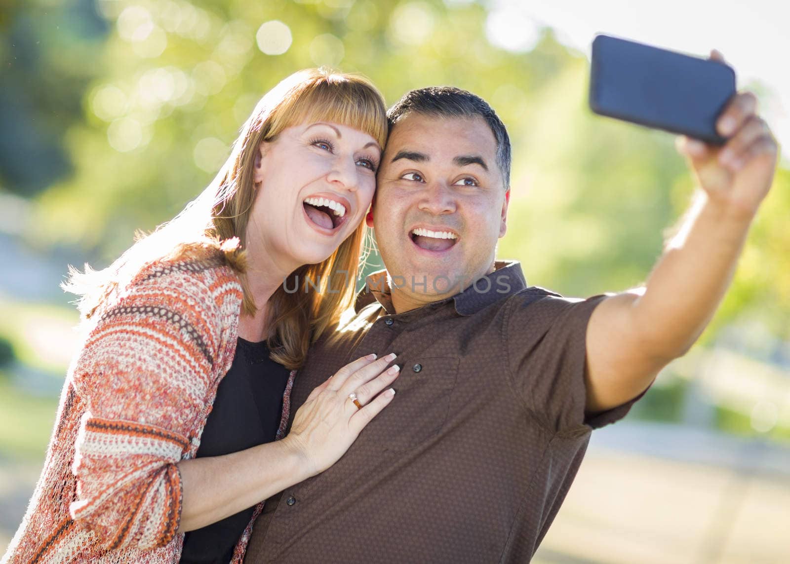 Attractive Mixed Race Couple Taking Self Portraits in the Park.