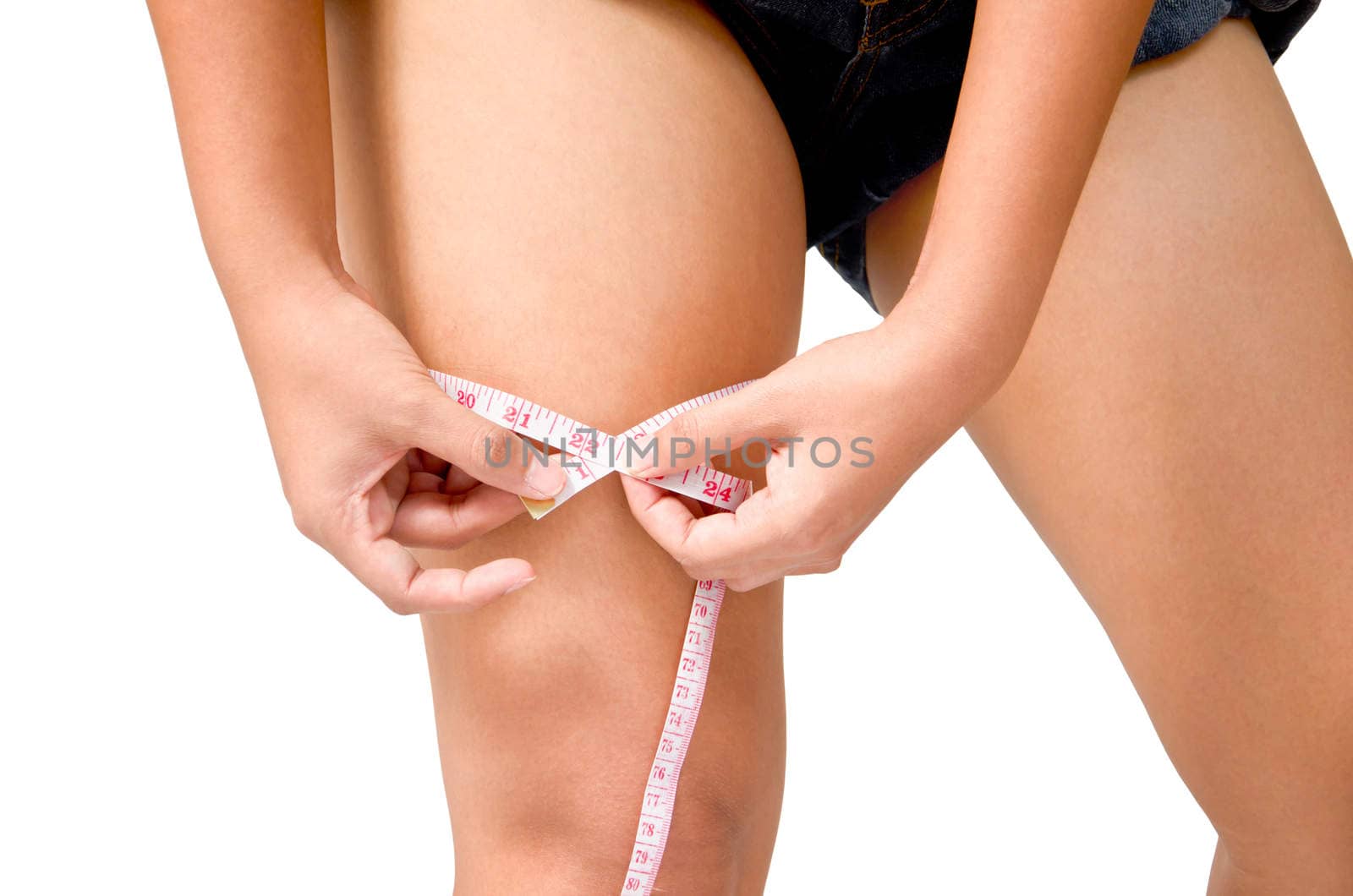 Young Girl Woman her Leg with a Metric Tape measure. Standing Sideways. Girl measures her thigh Measuring after weight loss.