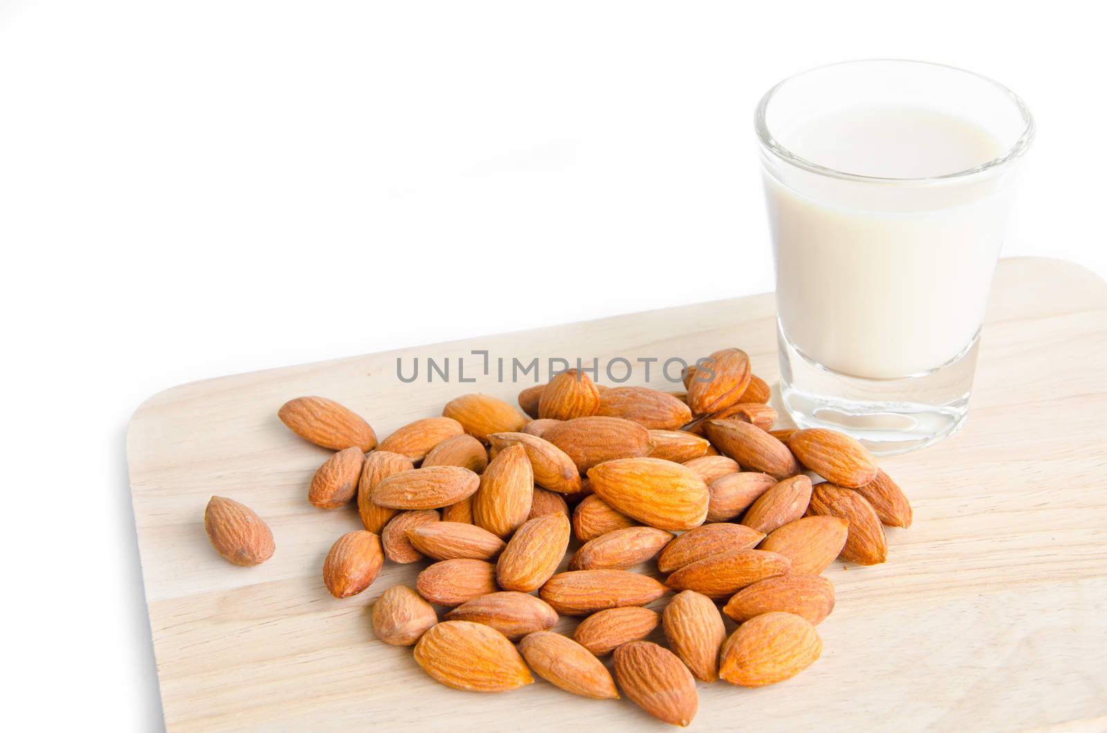 Almond milk in glass with almonds on wooden