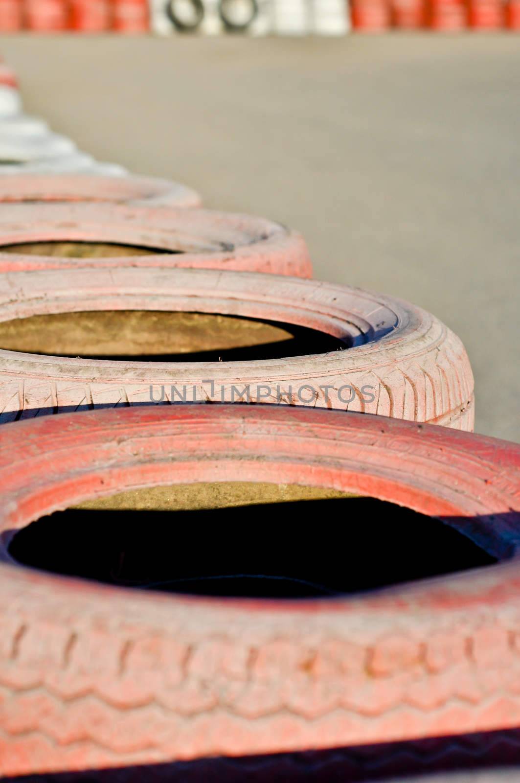 close up of racetrack fence of  red  old tires by vlaru