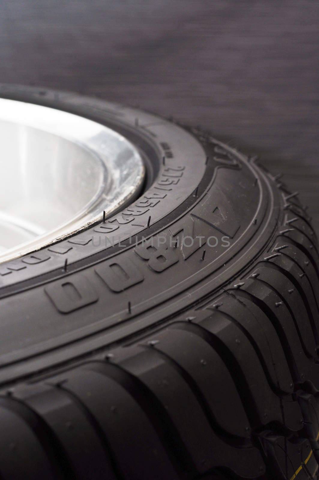 low-profile car wheel on a black background close up