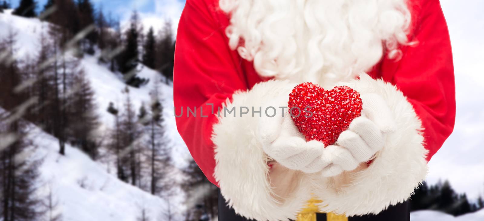 christmas, holidays, love, charity and people concept - close up of santa claus with heart shape decoration over snowy mountains