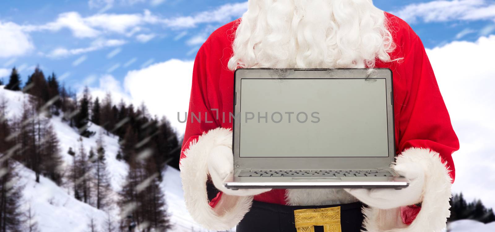 christmas, advertisement, technology, and people concept - close up of santa claus with laptop computer over snowy mountains