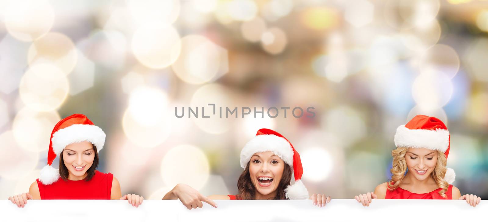 christmas, x-mas, people, advertisement and sale concept - happy women in santa helper hat with blank white board over lights background