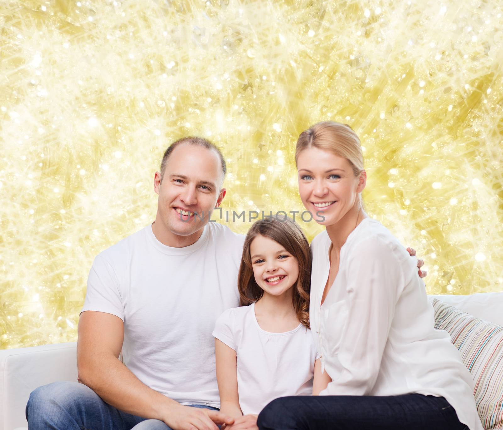 family, childhood, holidays and people - smiling mother, father and little girl over yellow lights background