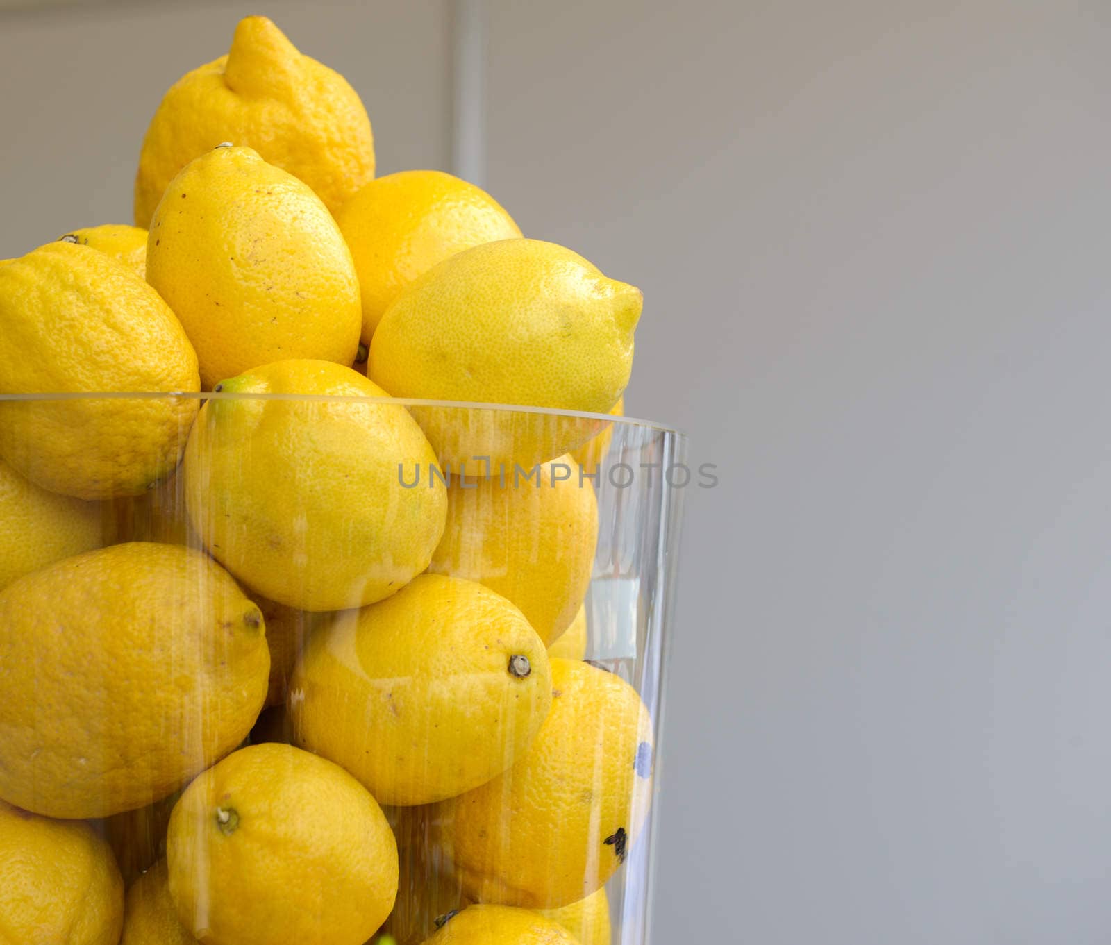 a lot of yellow ripe lemons in a glass jar