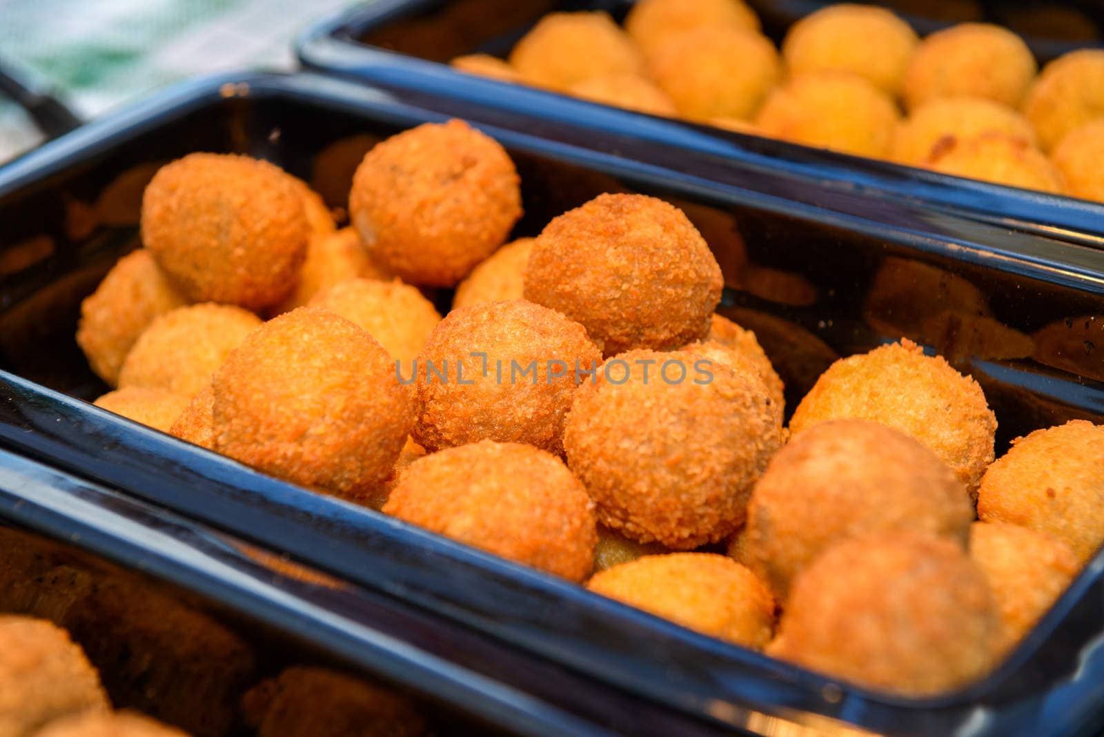 ruddy crispy cheese balls with spices in a metal tray