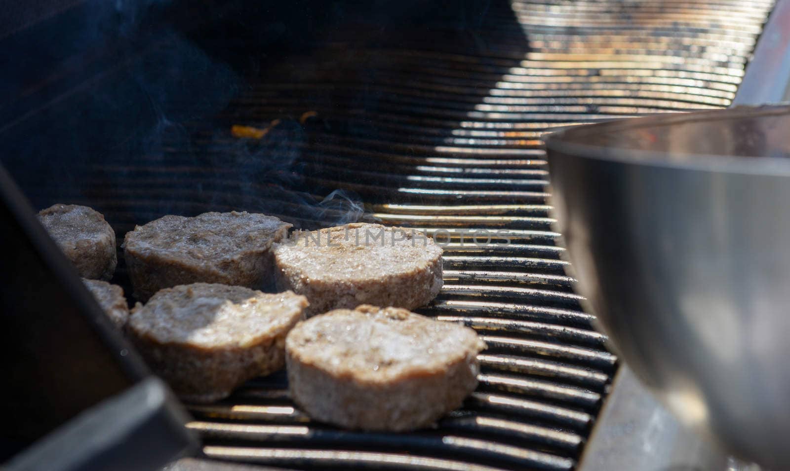 cooking steaks on a hot grill in a summer day