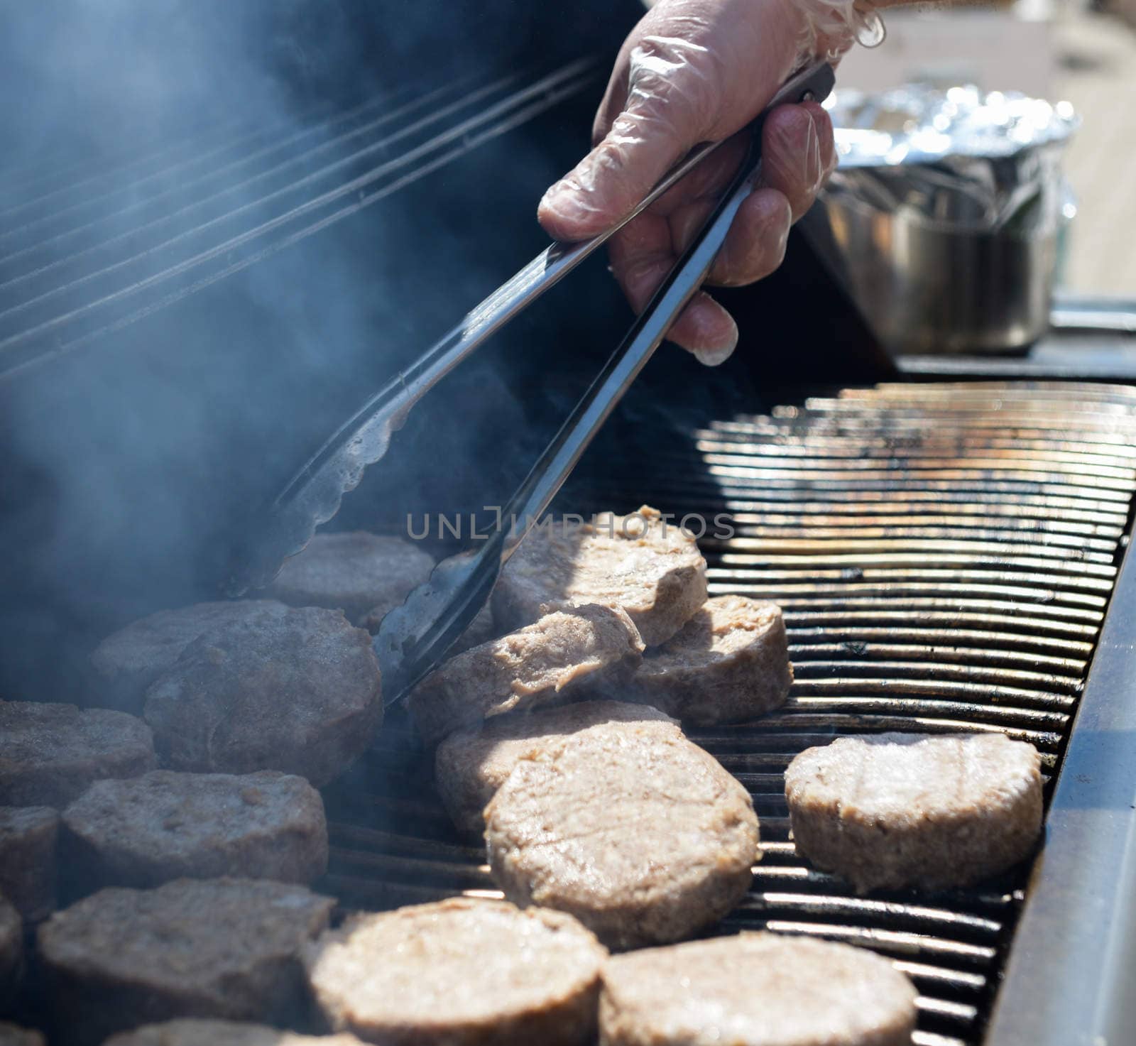 cooking steaks on a hot grill in a summer day