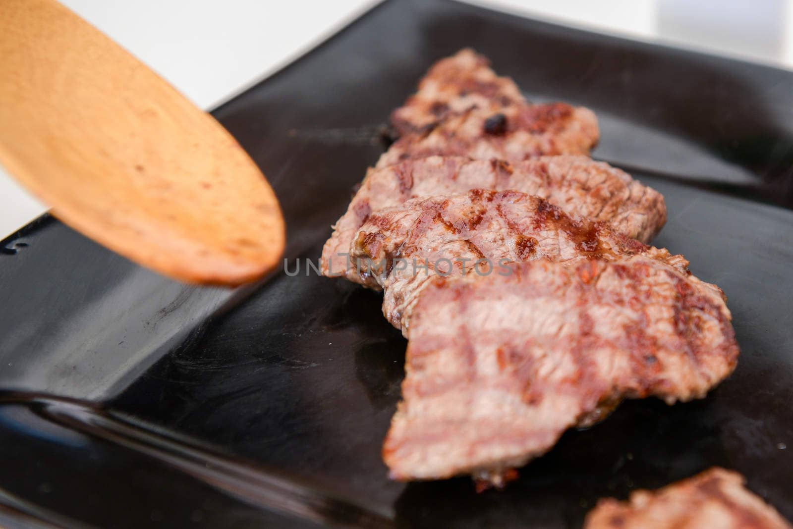 Delicious juicy steak on a black square plate