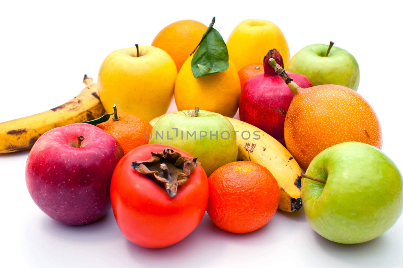 a lot of different fruits and green leaves on white background