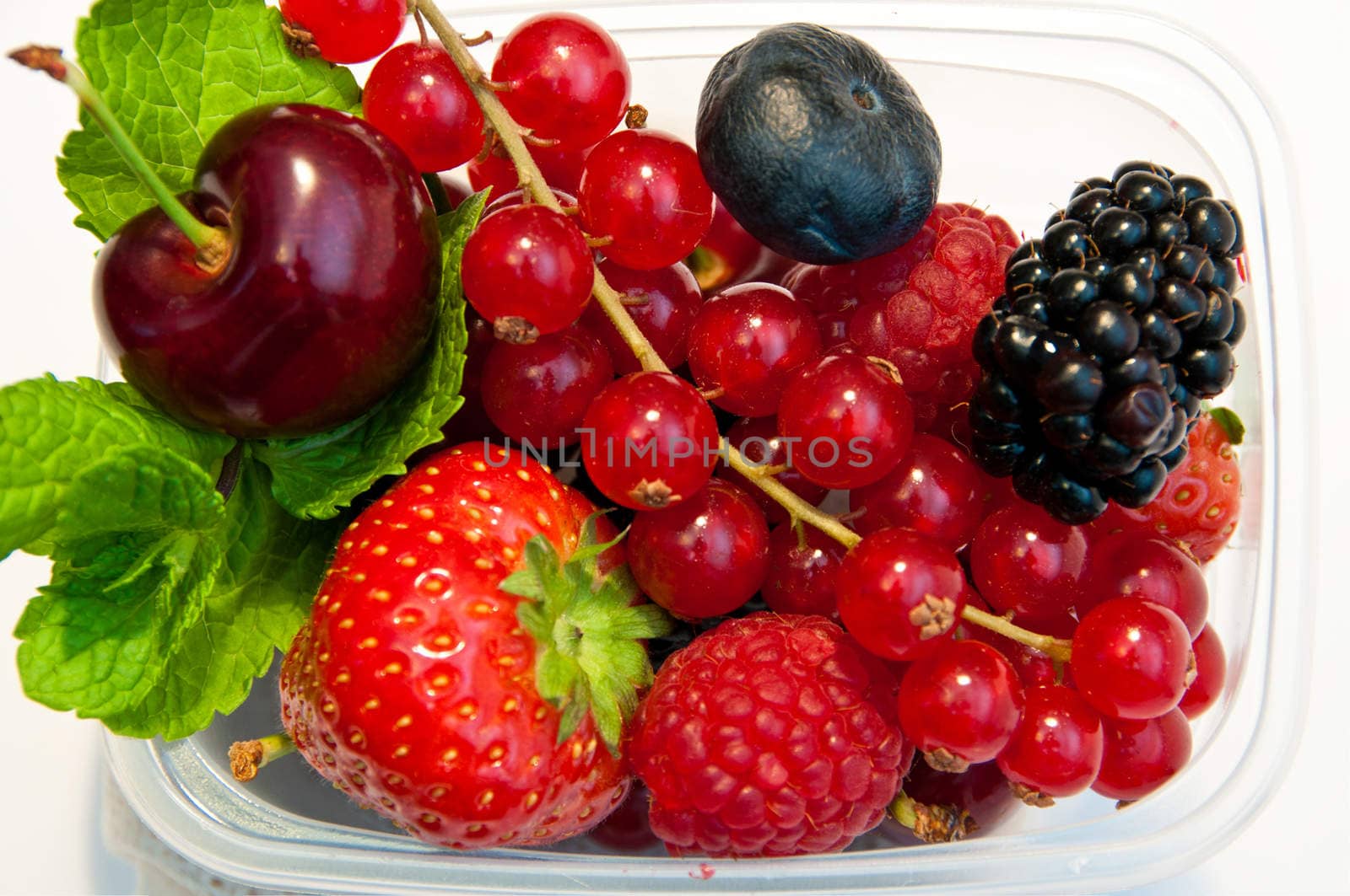 berries in a plastic box on a white background